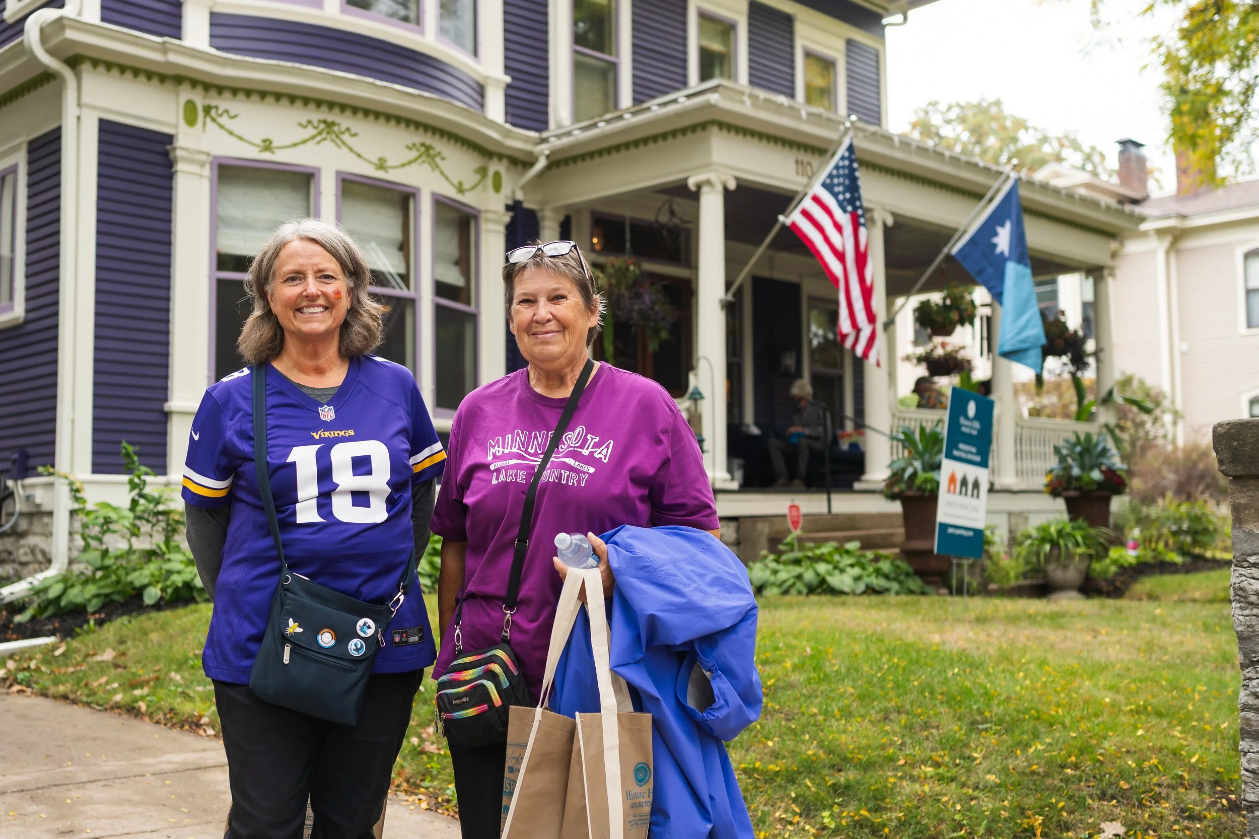 Two people standing in front of a purple house.