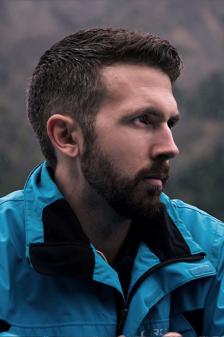 Man in a blue jacket with a beard, side profile