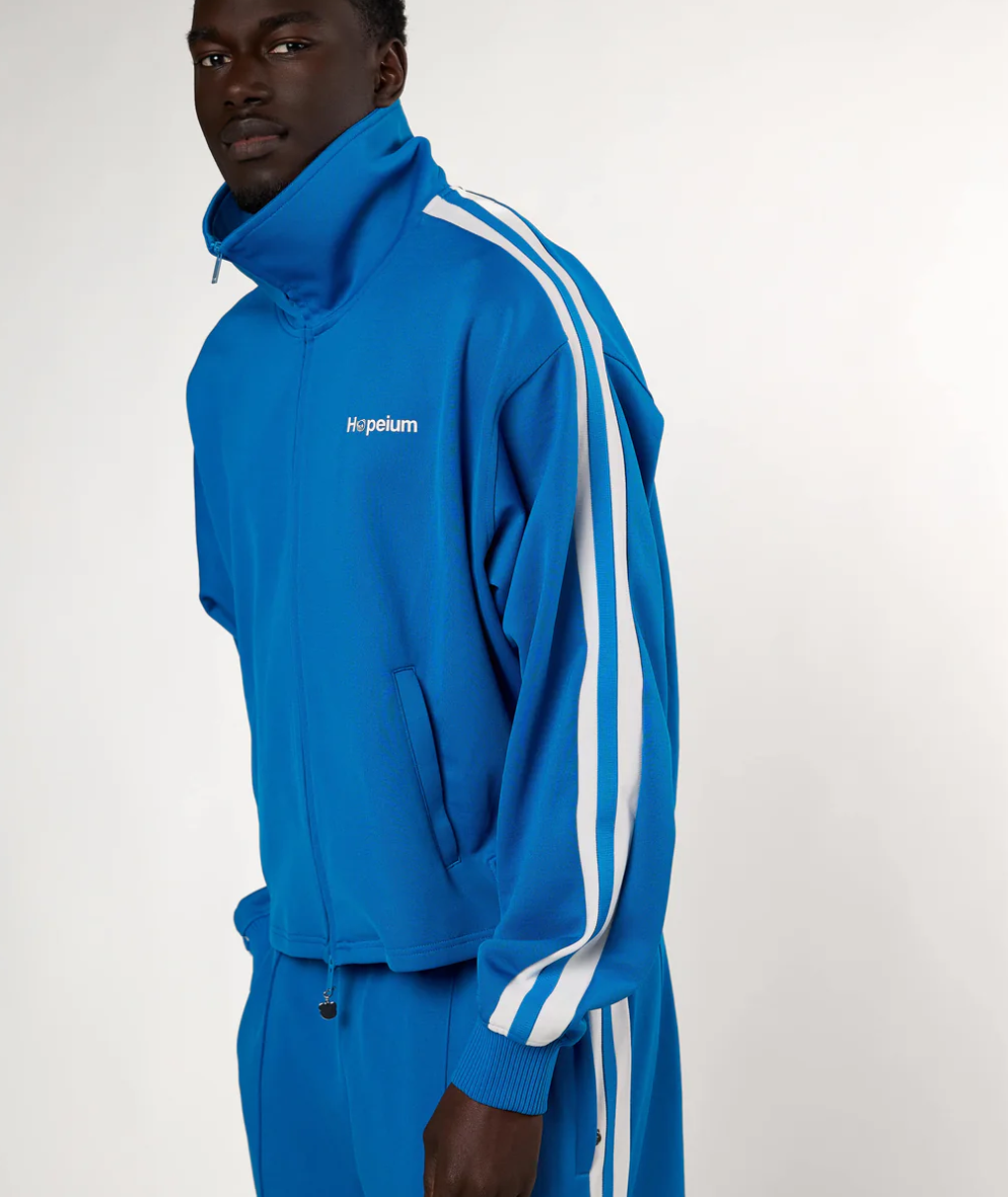 HOPEIUM track jacket in cobalt with cropped oversized fit, stripe sleeves, and logo details.