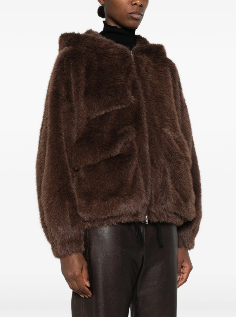 TELA Teddy Fur Jacket in Brown, featuring a plush teddy texture, hood, front zip closure, oversized side pockets and front patch pocket.