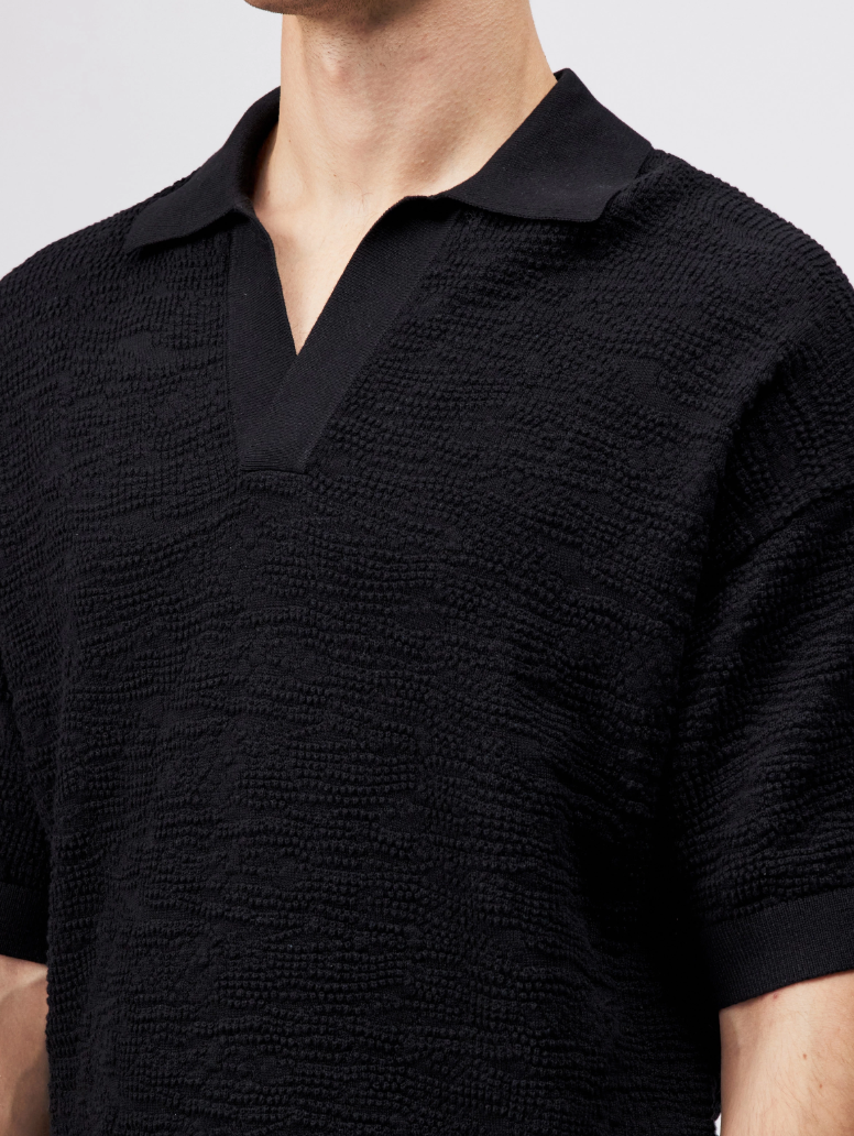 Black Drykorn LAURENZZO oversized cotton knit polo for men with short sleeves, wide placket, and soft textured knit for modern casual style.