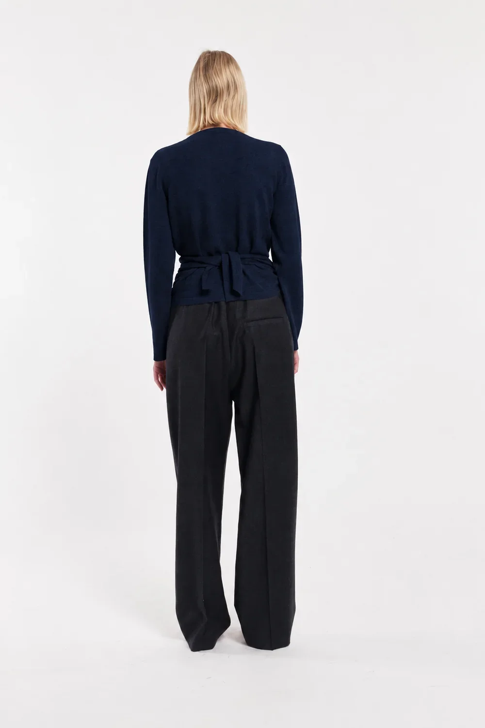 TELA Crossover Knit Top in Blue, crafted from soft carded wool with a wrap-effect front, draped waist and adjustable back tie.