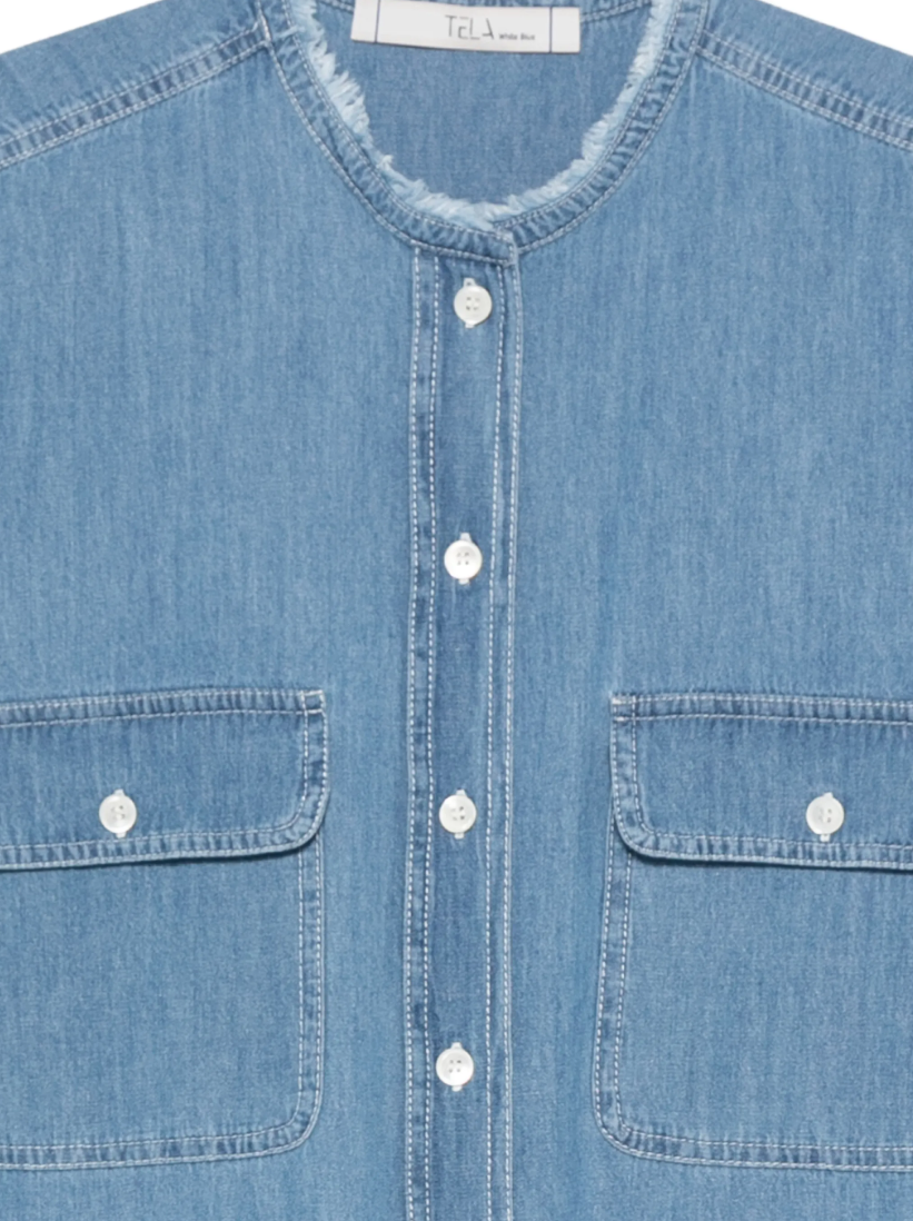 Blue sleeveless denim shirt by Tela, made in Italy with flap pockets and frayed details for a modern, edgy look.