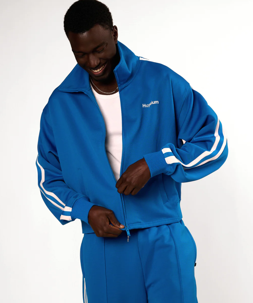 HOPEIUM track jacket in cobalt with cropped oversized fit, stripe sleeves, and logo details.