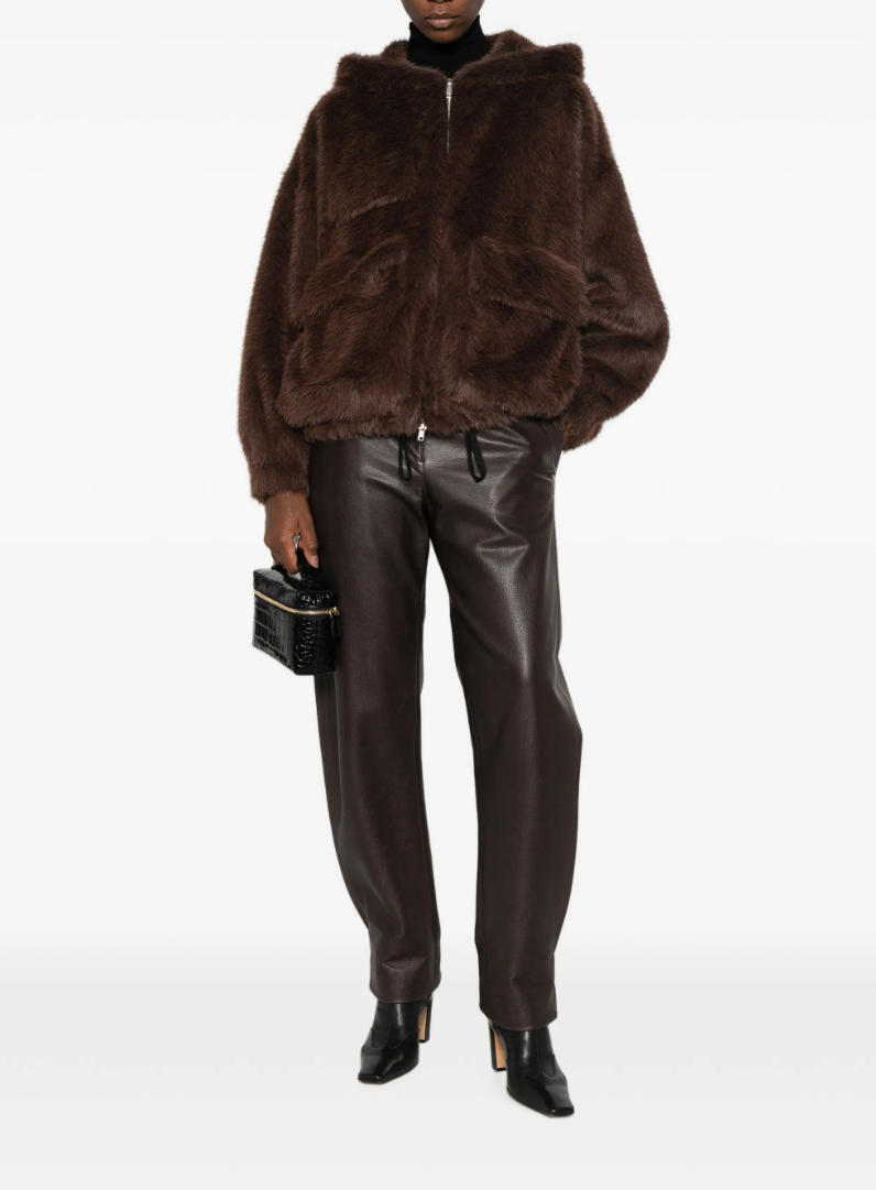 TELA Teddy Fur Jacket in Brown, featuring a plush teddy texture, hood, front zip closure, oversized side pockets and front patch pocket.