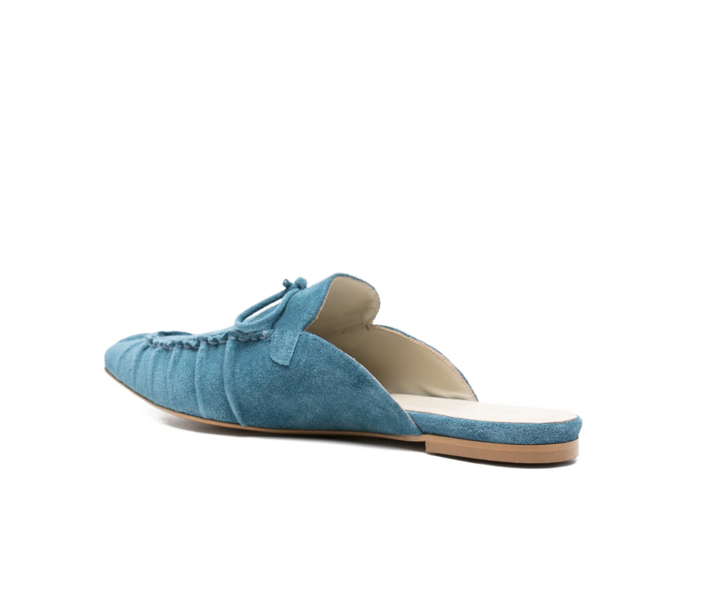 Blue suede tie-detail flat mules by Tela, made in Italy with slip-on design and pointed toe for chic everyday style.