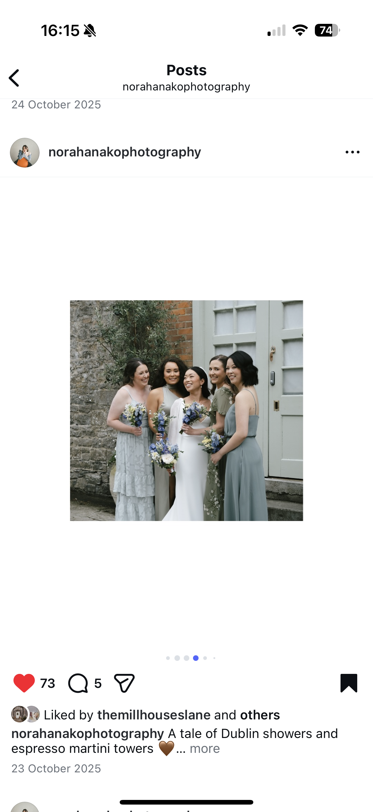 Group of five women in wedding and bridesmaid dresses standing outdoors against a stone wall and a white door, holding bouquets of flowers, smiling and posing together.