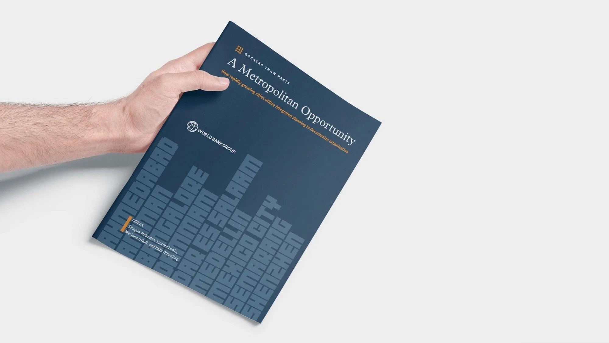 Person holding a blue report titled 'A Metropolitan Opportunity' with the World Bank Group logo on the cover.