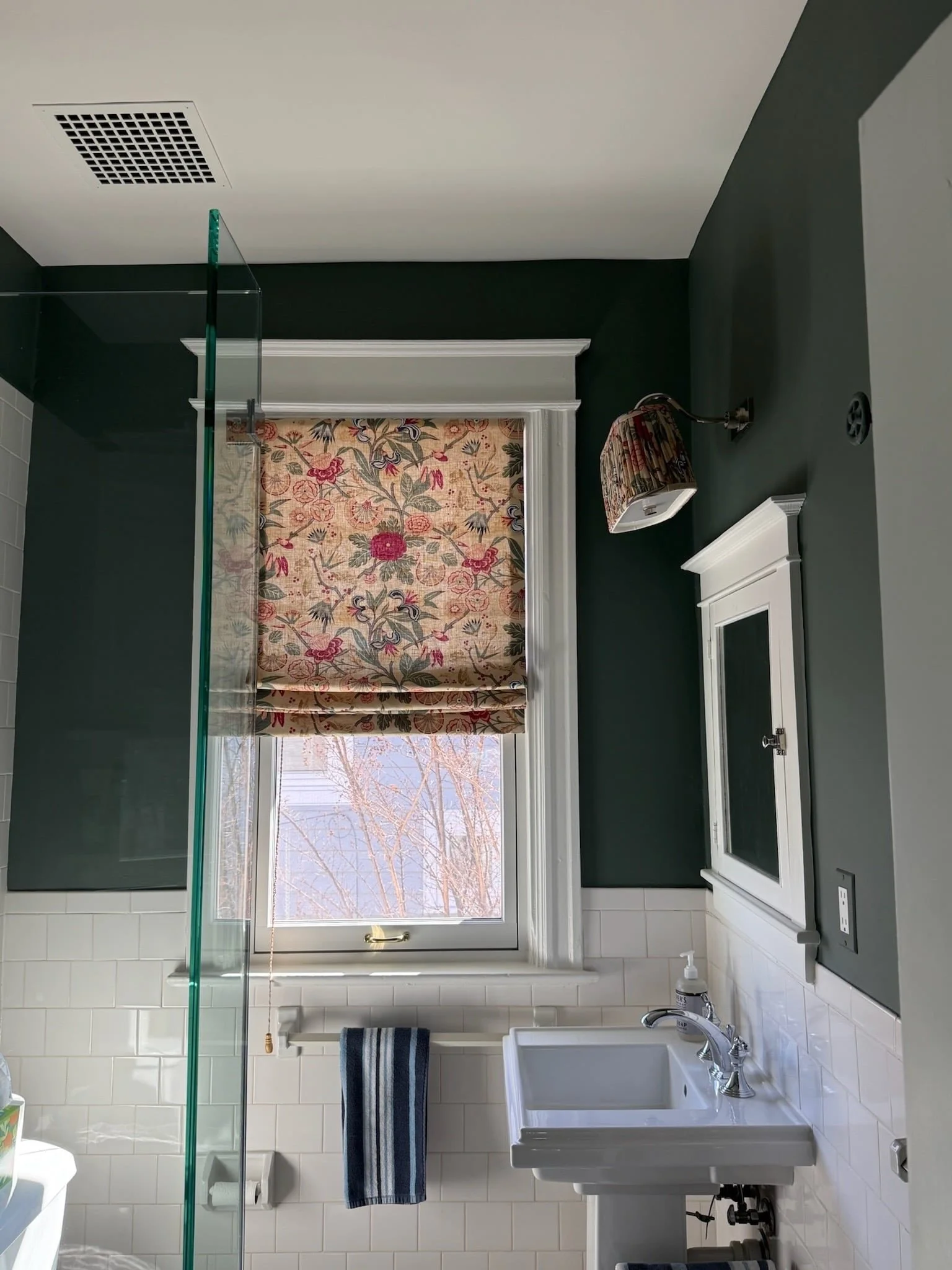 With the classic wall color, tile, and trim in this Chevy Chase powder room, bringing in a patterned Roman shade like this creates a bit of an unexpected moment. It&rsquo;s even carried into the light shade, which I love.

It&rsquo;s a good example o
