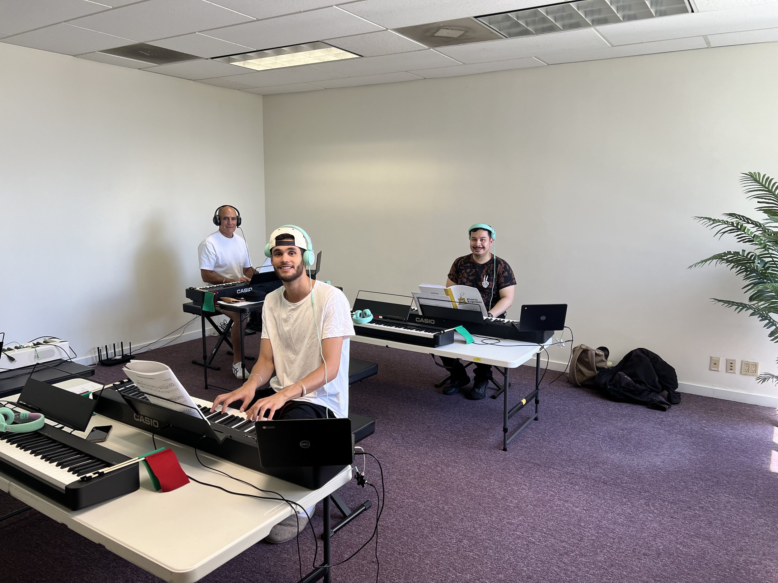 Adults smiling in a Piano Express class