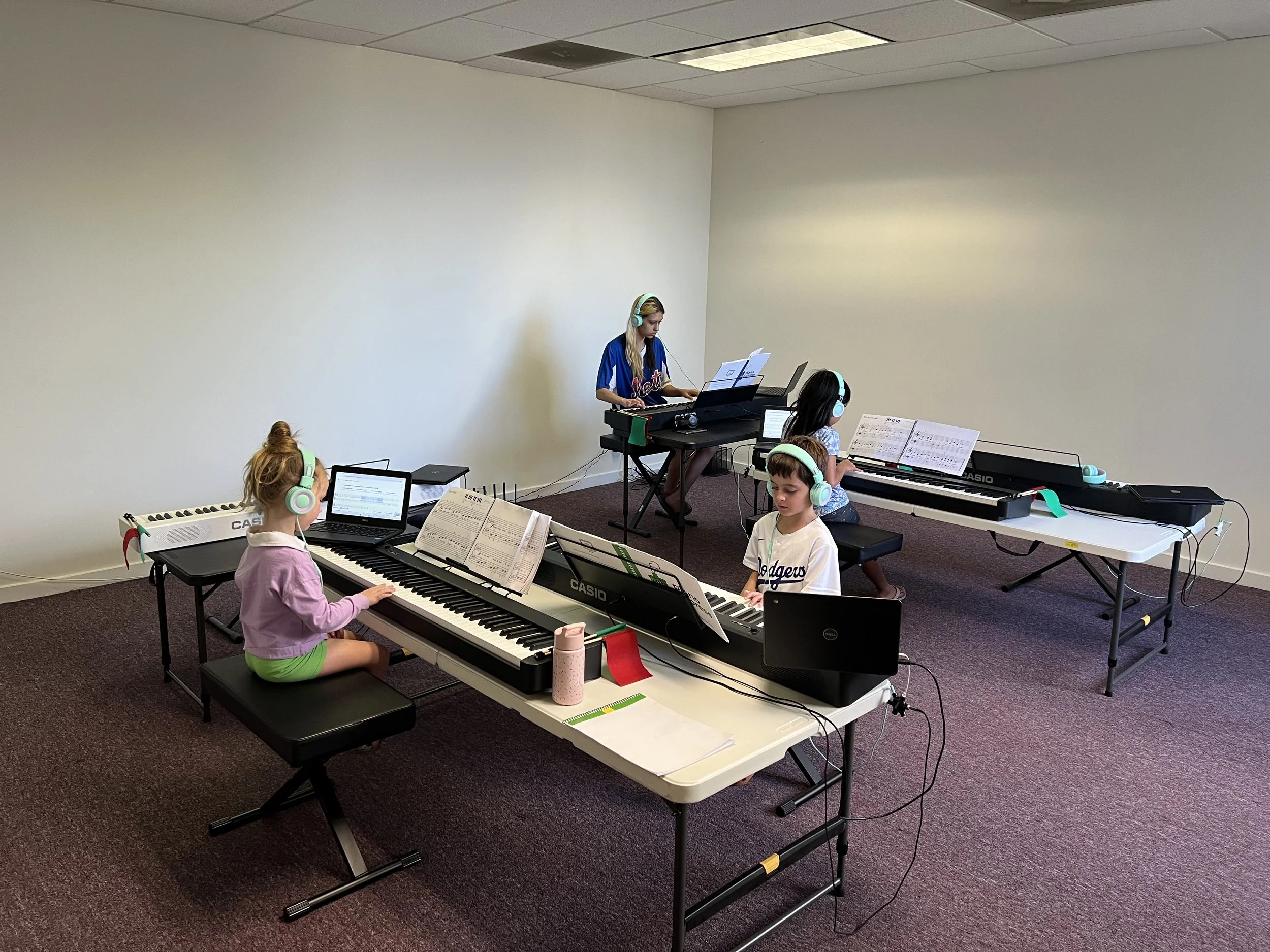 Young students focused on their practice in a Piano Express class