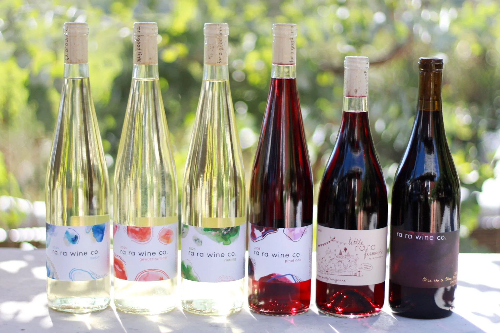 6 wine bottles in an outdoor setting.