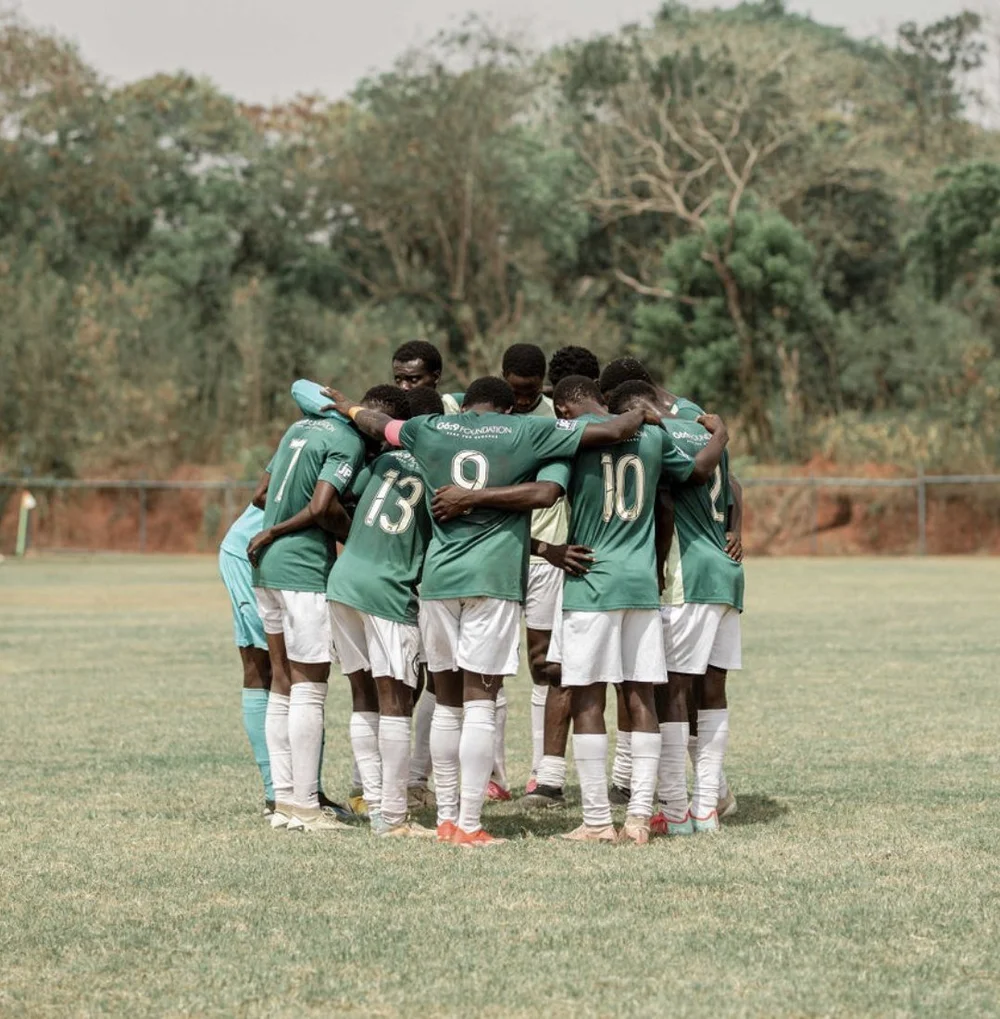 G6:9 Foundation players in a huddle, arms around each other