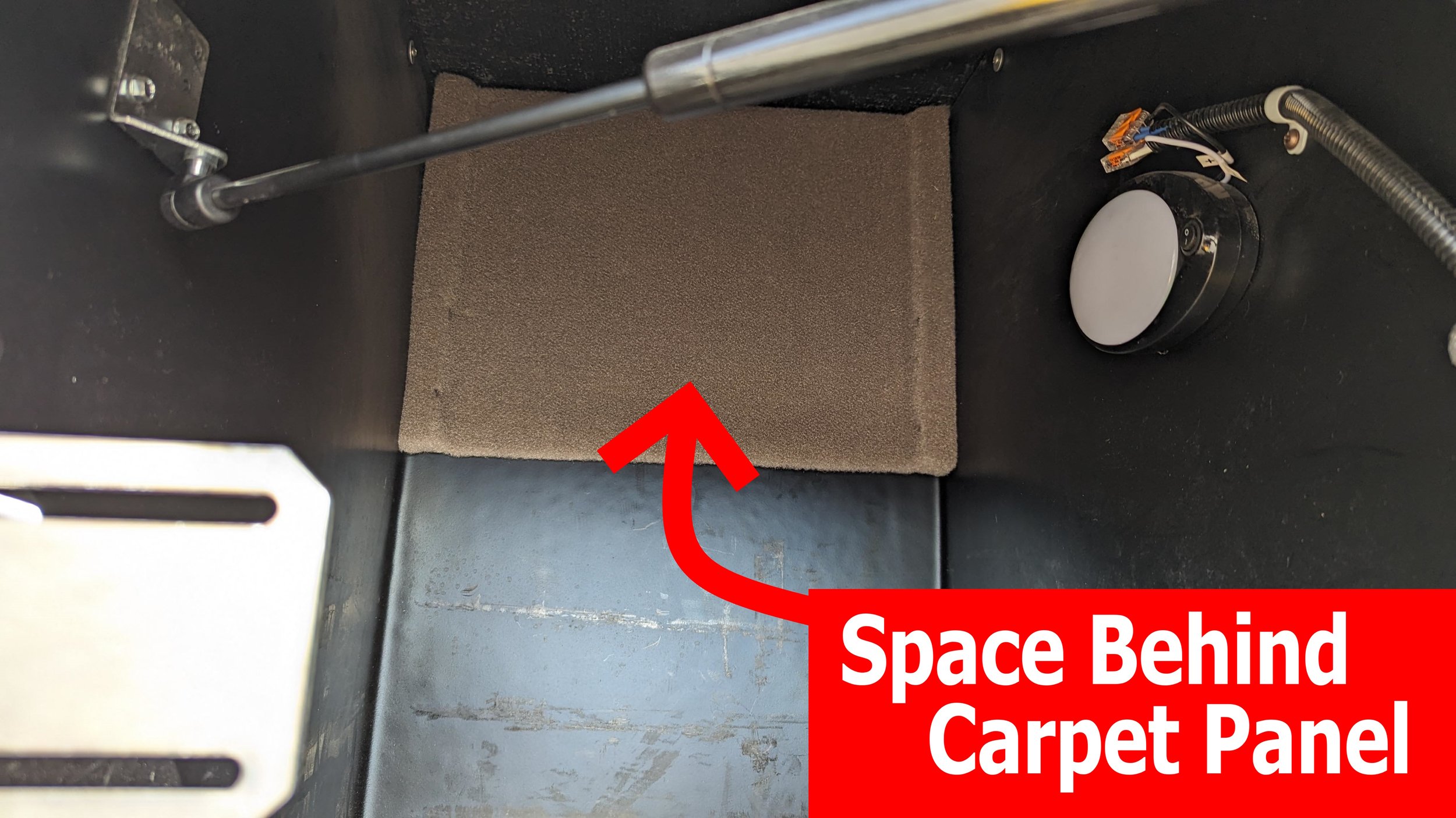 Extra storage space is behind this carpeted panel.