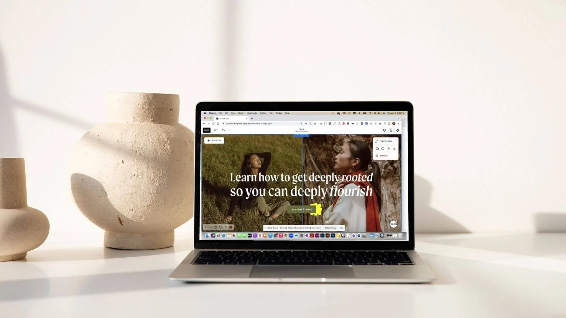 Laptop displaying a webpage with the text "Learn how to get deeply rooted so you can deeply flourish" on a white desk, flanked by three white ceramic vases of various shapes and sizes against a plain white background.