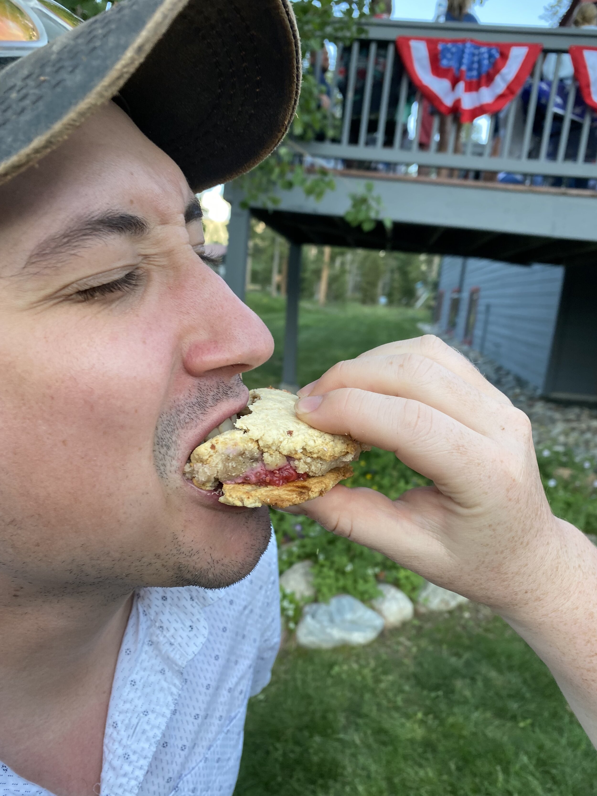 Alex opening his mouth for a bite of cookie dough sandwich