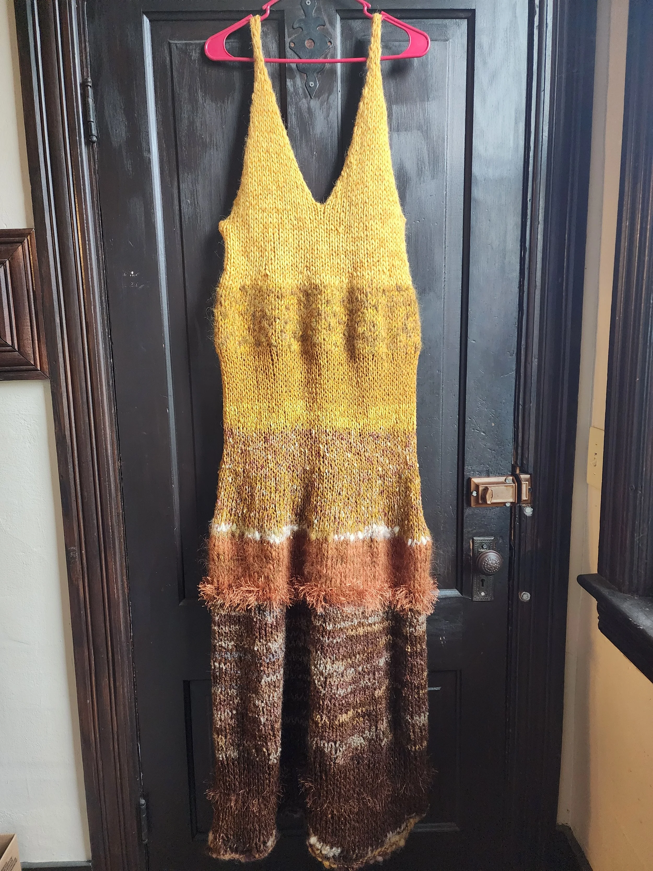 earth goddess hand-knit maxi dress in gradient of brown, orange, and golden yellow.