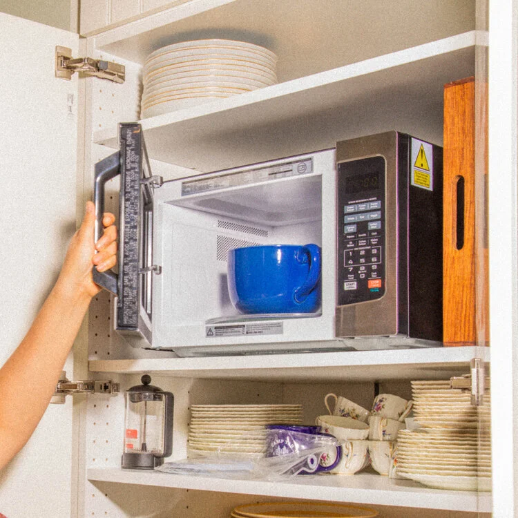 a person putting the bowl in the microwave