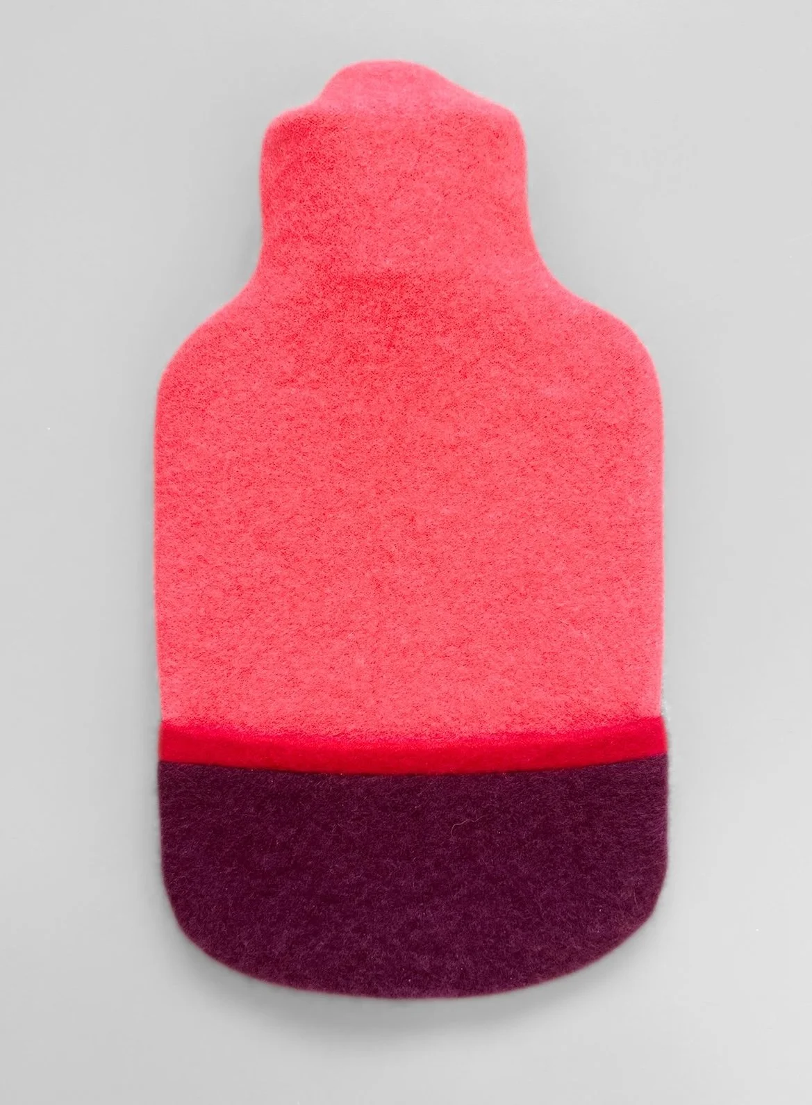 Cashmere hot water bottle in coral and burgundy.