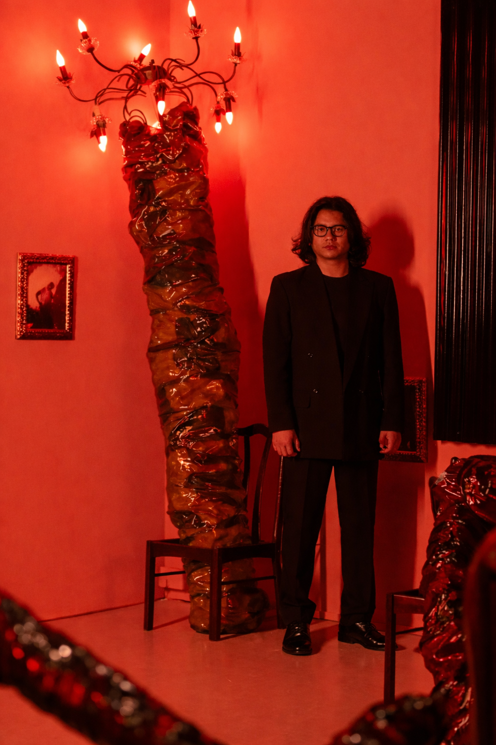 Singaporean artist Masuri Mazlan posed beside his sprawling large-scale installation work, can haunting be another way of enduring? at Singapore Art Museum.