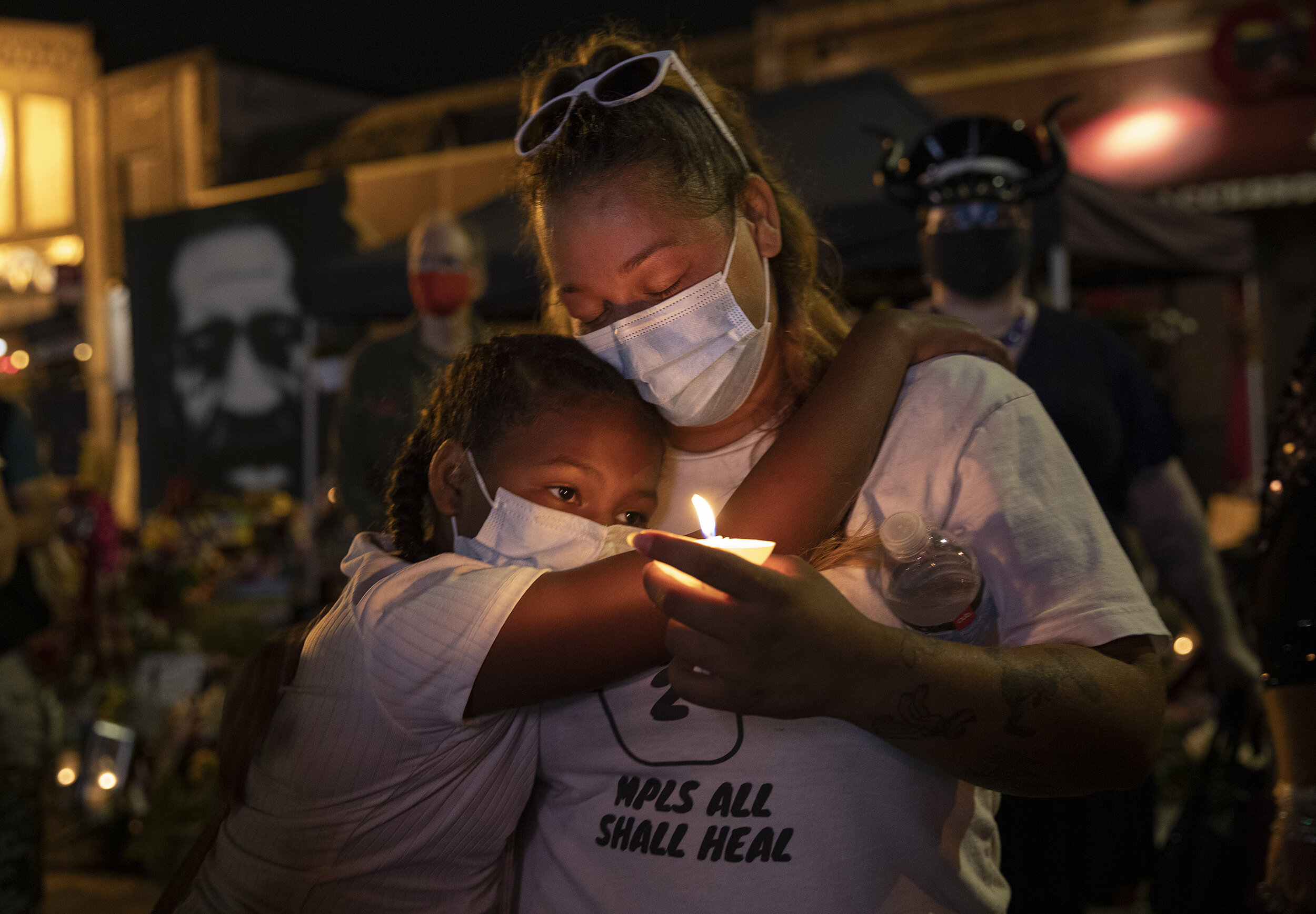  Innocynce Johnson, 11, and Kia Bible embrace at George Floyd Square during a multi-faith prayer candlelight vigil to honor Jacob Blake and Black lives. 