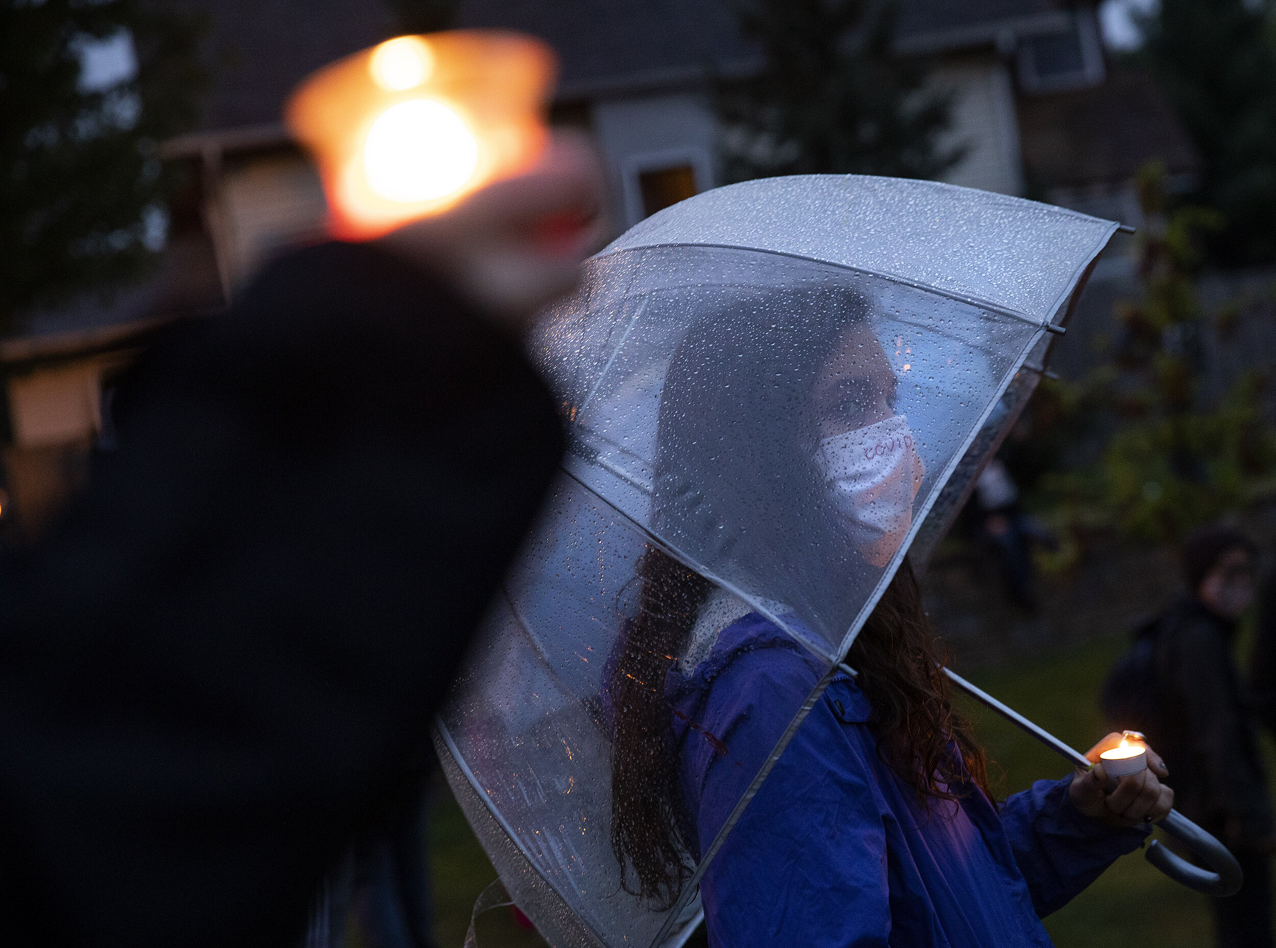 Meg Veitenheimer of St. Paul shelters from the rain during a vigil at the Say Their Names cemetery in Minneapolis. 