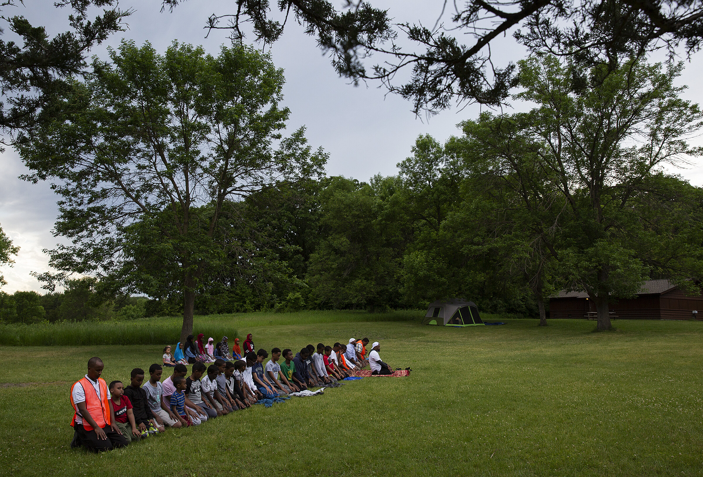  Campers gather on the campground for the midday and afternoon prayers, which were combined because of travel.  Youth and Family Circle  is dedicated to connecting city kids and children of refugees to outdoor activities like hiking, boating and fish