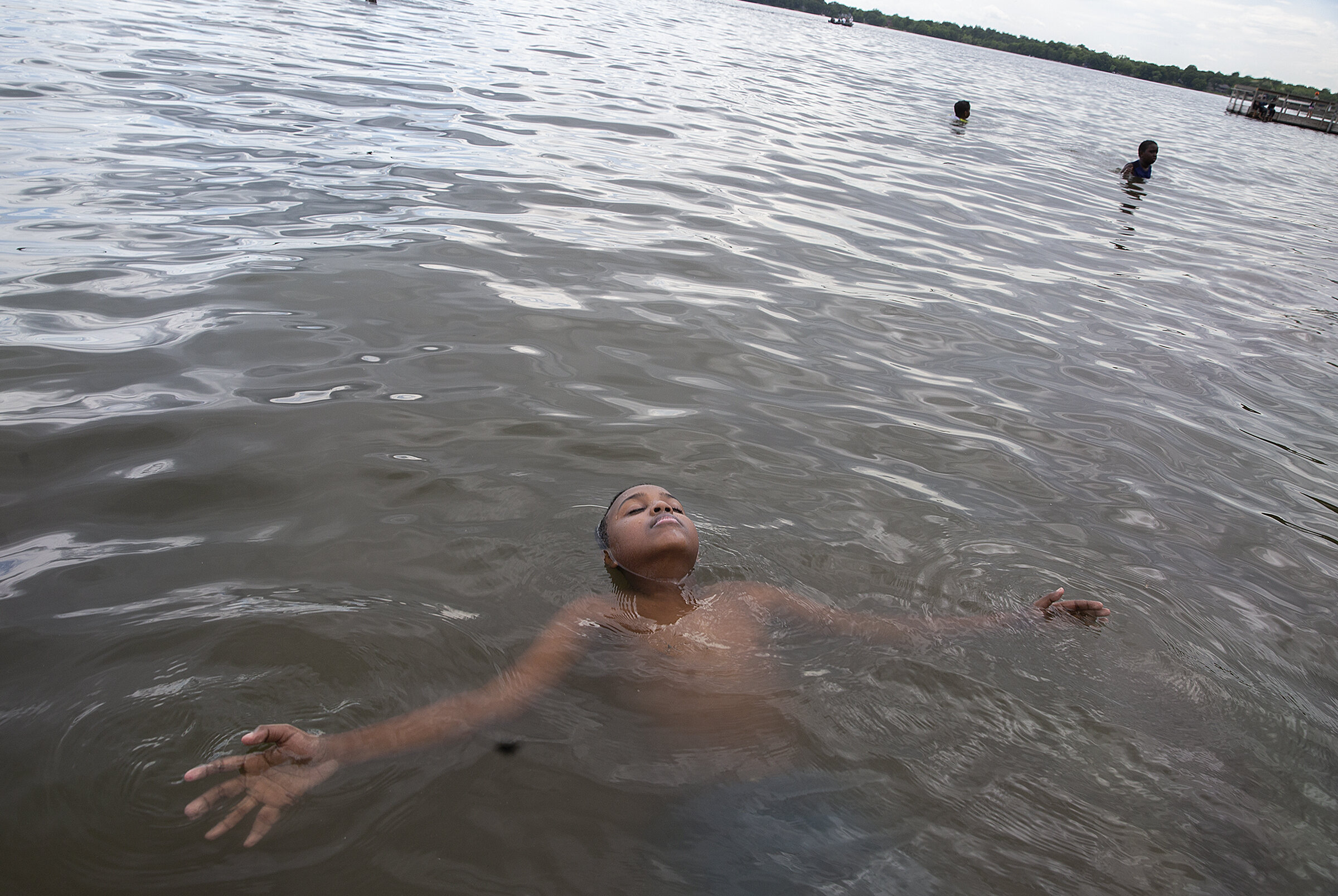  Abdirahmen Adam, 13, floats in Lake Andrew. Language, lack of information and finances are often barriers to kids enjoying Minnesota’s lake life. 