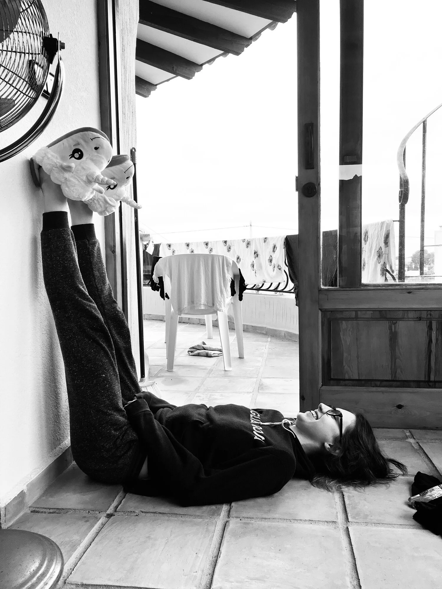 female+lying+on+her+back+with+legs+up+against+wall+laughing+by+Nathaniel+Rosa+shot+on+iphone.jpg