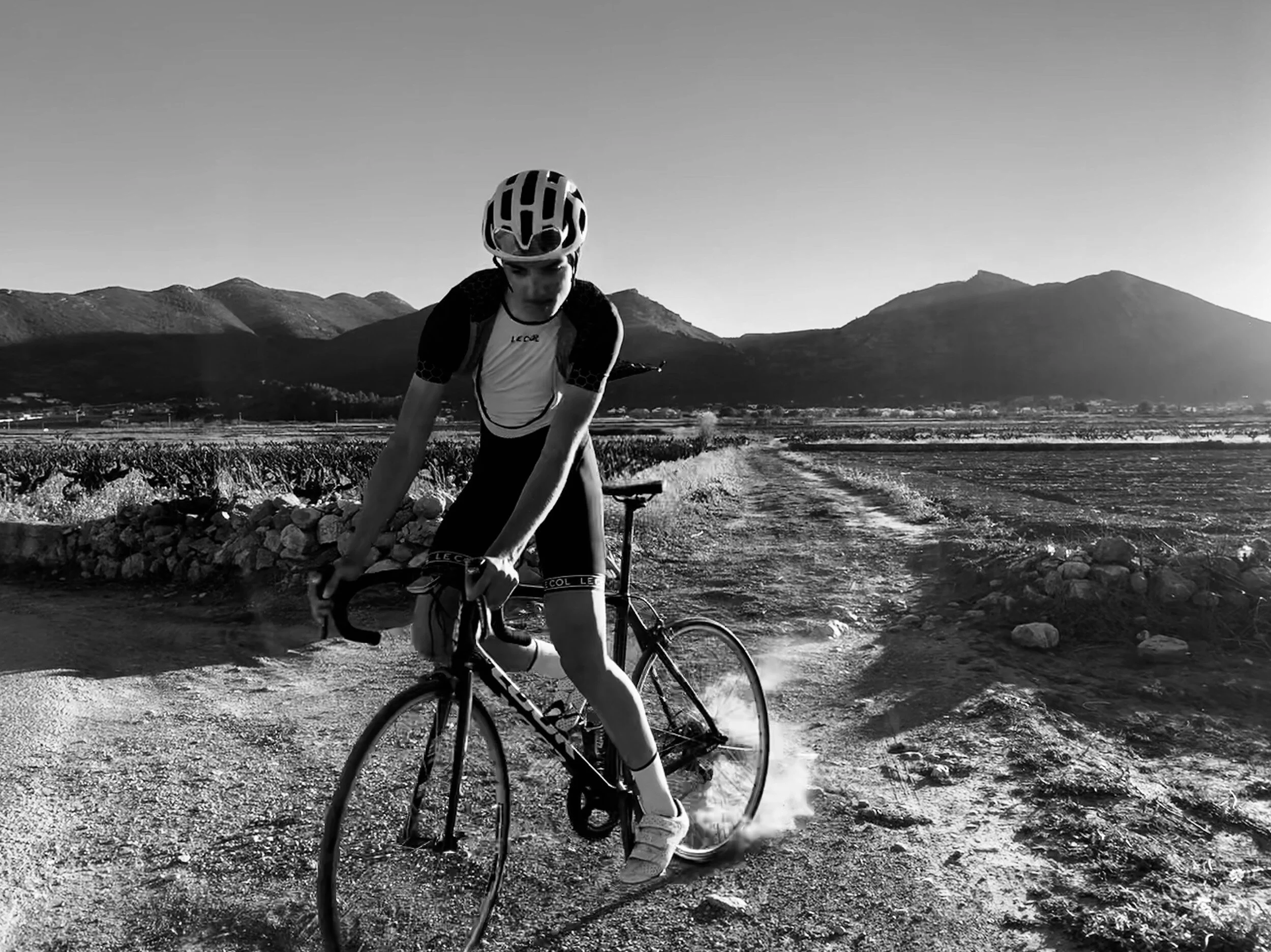 cyclist+doing+a+skid+on+gravel+with+mountains+in+the+background+by+Nathaniel+Rosa.jpg