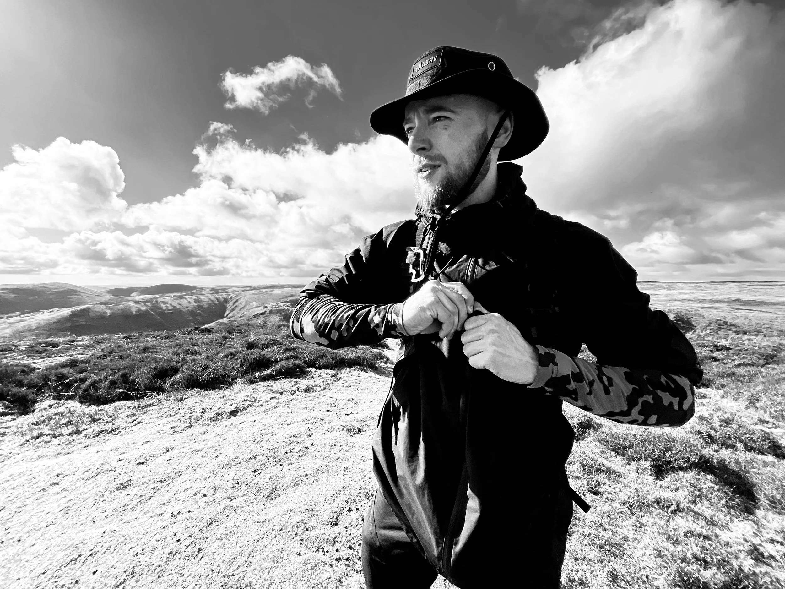 a+man+wearing+a+hat+posing+at+the+top+of+a+hill+while+out+hiking+by+Nathaniel+Rosa+shot+on+iphone.jpg