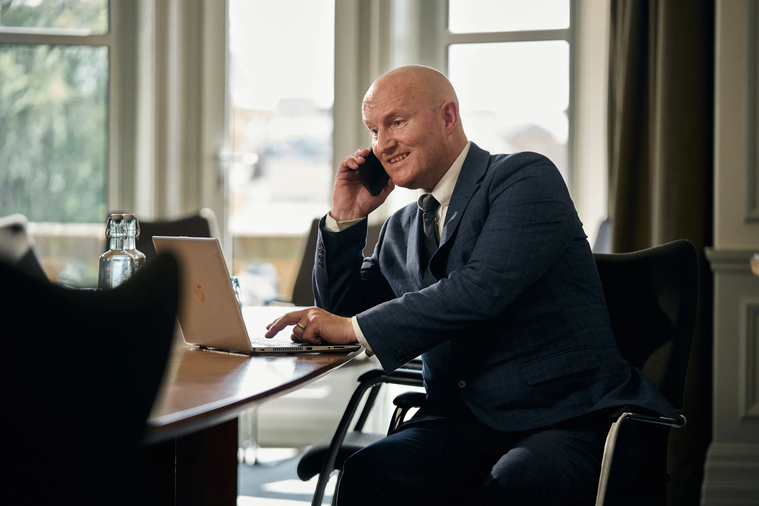 Hospitality photography by Nathaniel Rosa - male administrative employee working on laptop while talking on phone.jpg