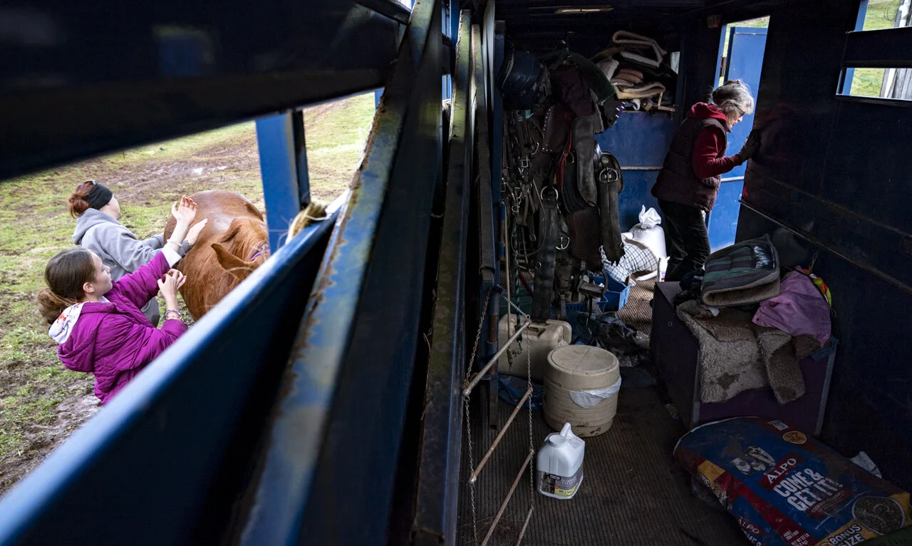 Lia Bonesteel, left, and her daughter, Saphira, groom one of Heidi’s horses after a training lesson as Heidi walks out of her trailer after putting back equipment, in Shade, Ohio. Lia used to ride horses growing up, and is glad for the opportunity