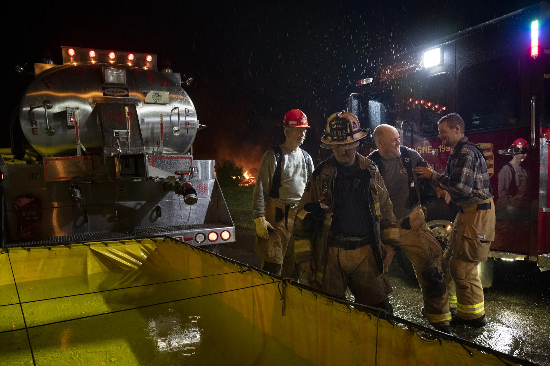  Mike Hart, right, pretends to push fellow fire fighter Jameson Allen into the portable water reservoir after a training burn while veteran fire fighter Jim Goodfellow looks on, in Stewart, Ohio. “I needed to get this place back,” said Mike, while sp
