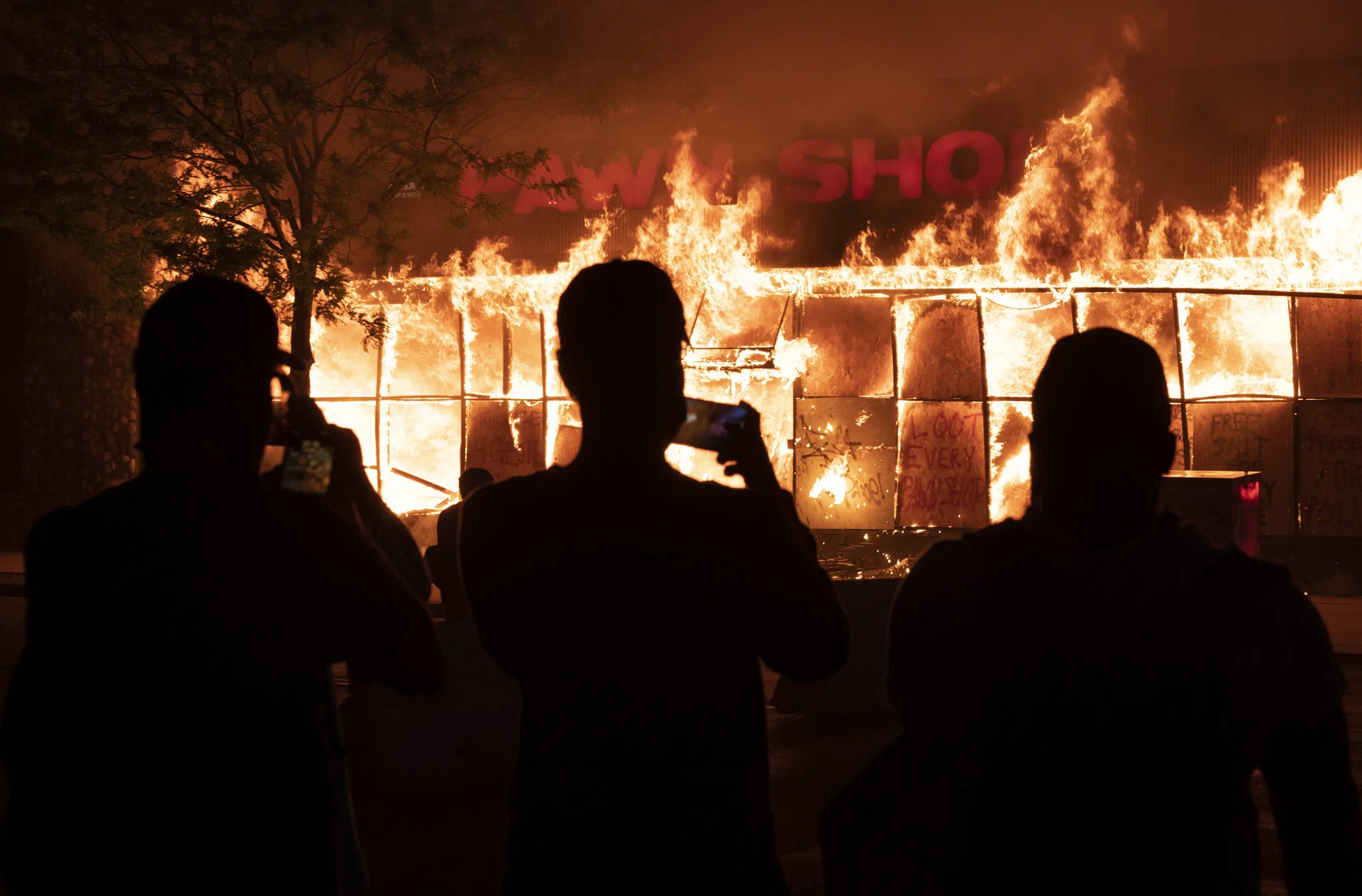  Protesters watch as a pawn shop burns on East Lake Street in Minneapolis, Minnesota, on May 28, 2020. Protests have continued following the death of George Floyd, who was killed while in Minneapolis Police Department custody. 