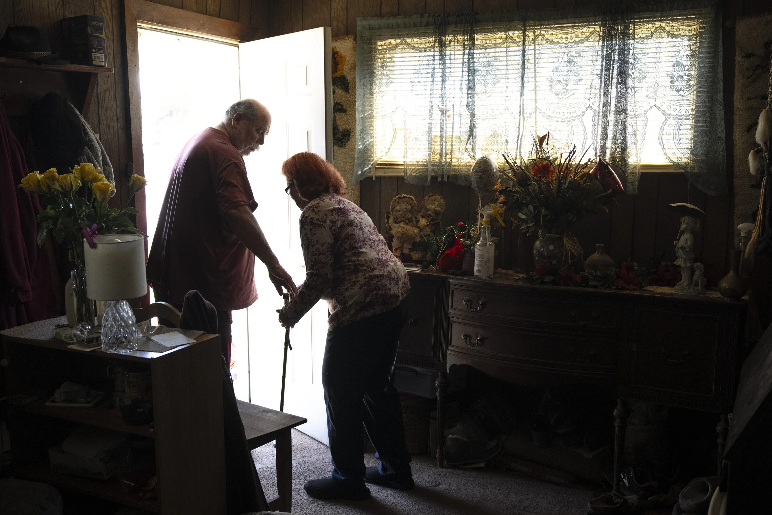  Wayne reaches out to hold Lynne Roberts’ hand as they leave their home in Butte, Montana before driving to lunch. As Lynne’s mobility decreased, she and Wayne went out less and less for travel, eating and entertainment. It became a rare occurrence f