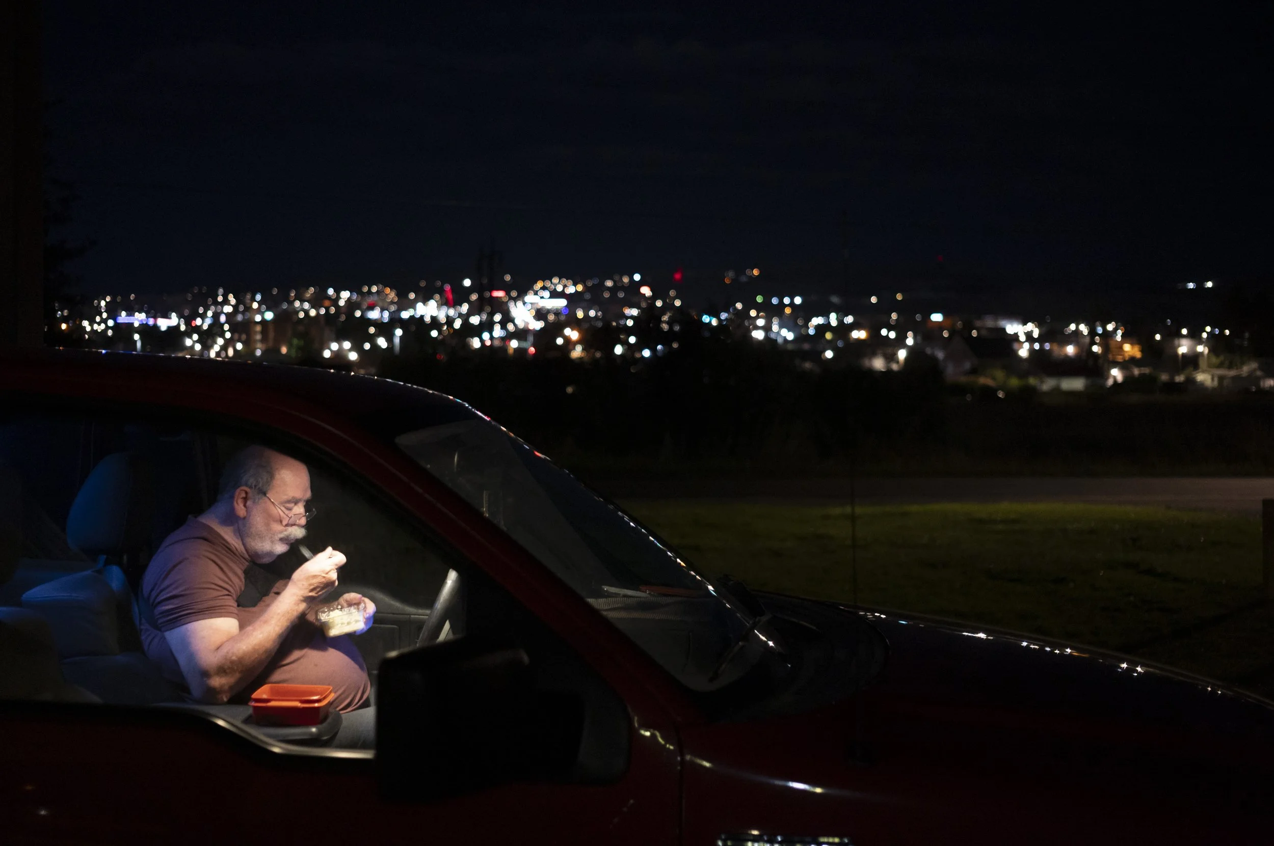  While waiting for the newspaper truck to arrive, Wayne eats a light meal late Monday night. Wayne works for The Montana Standard delivering newspapers which can take him into the early morning hours to complete. This allows him to work when Lynne is