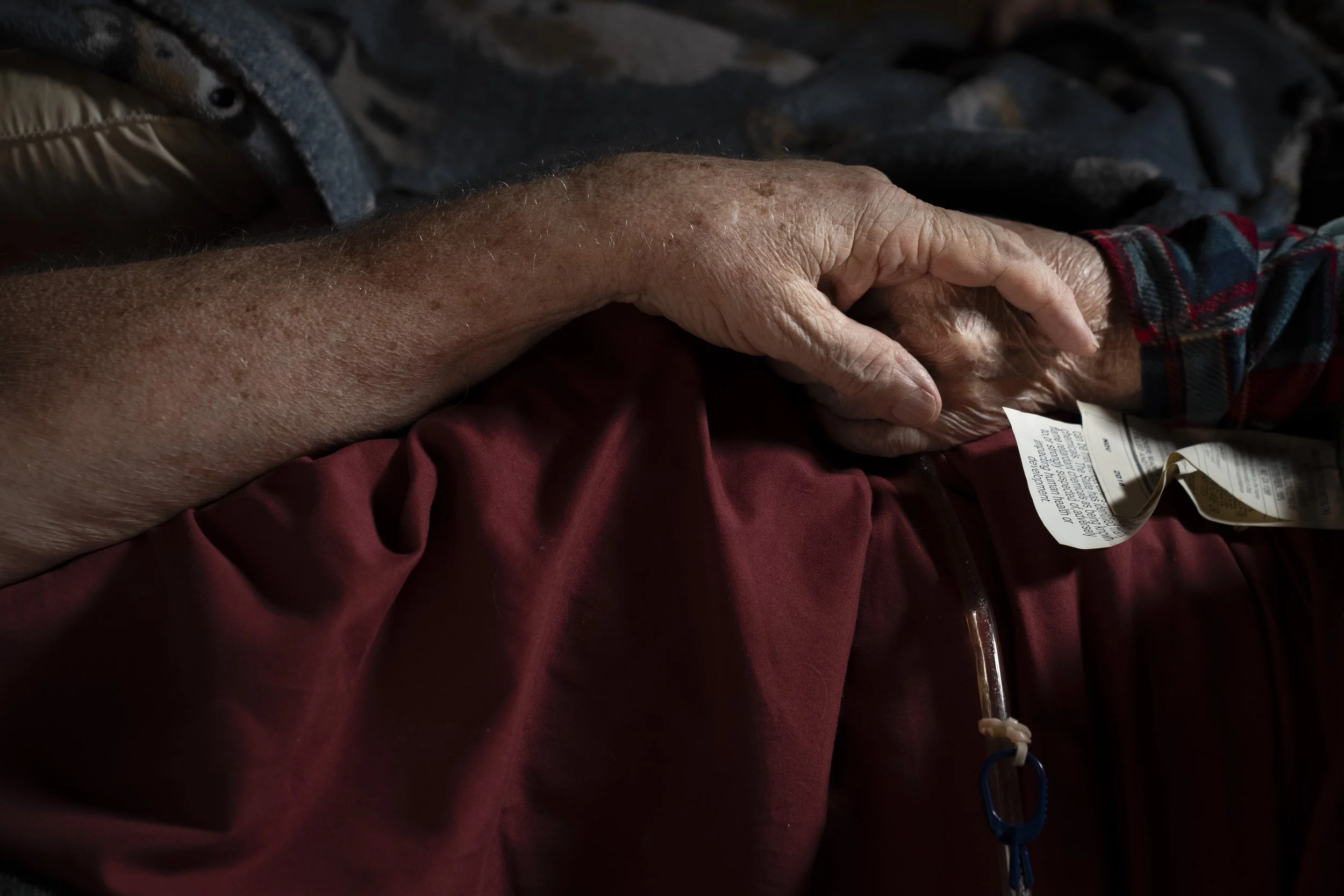  Now in hospice, Lynne tightly grasps Wayne’s hand while lying in bed. Lynne is having increasing difficulty swallowing and has moved away from solid foods. She now drinks water through a straw or by sucking on a wet sponge. “This is no way to live,”