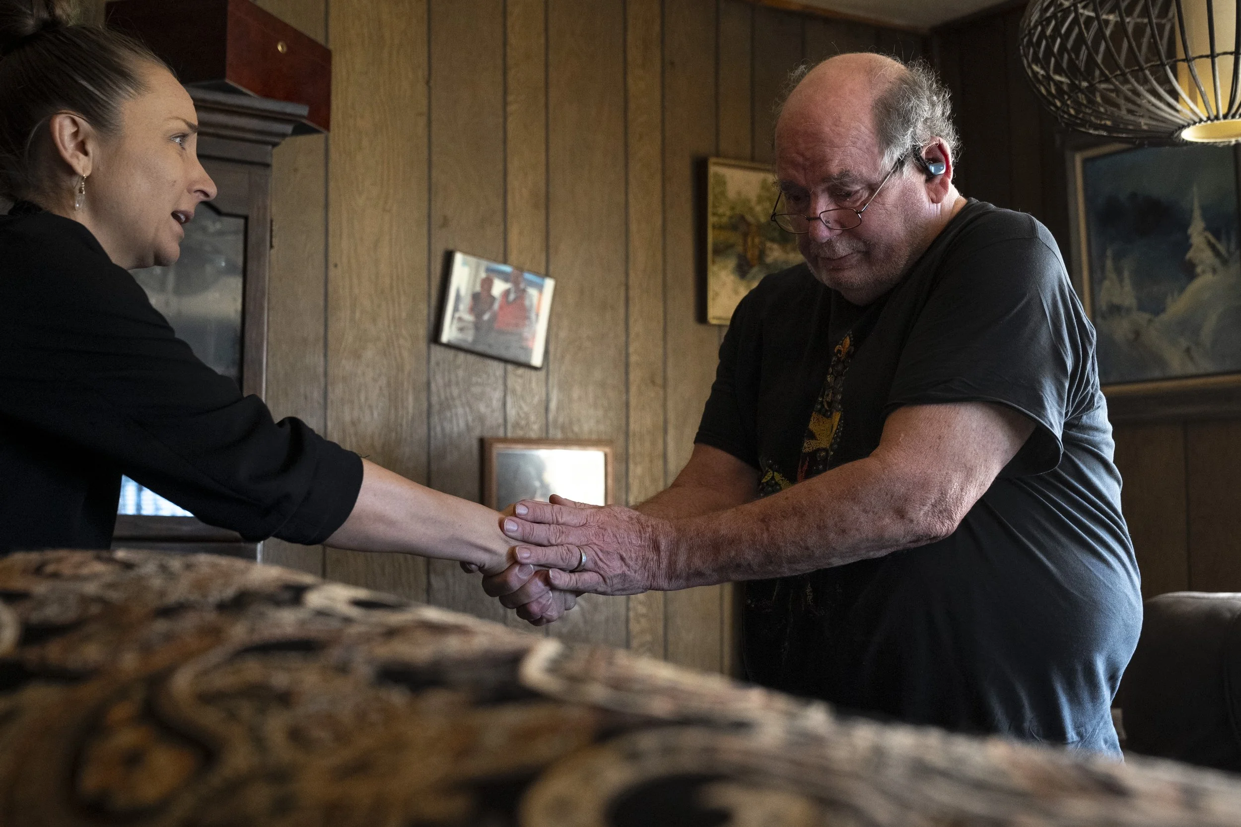  Lynne Roberts died at 8:45 am on Thursday morning, June 6, 2024 in her home. Wayne grasps the hand of Funeral Home Director Bri Mulvaney as Lynne’s covered body is taken away. 