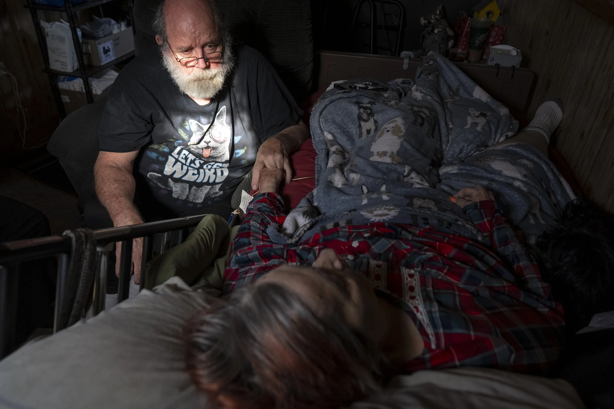  Wayne sits with Lynne in what he expects to be her last day of life, on Monday, May 27, 2024. “It’s a conflict. I want to take care of her, I want her to be happy. And I want her to die,” said Wayne. “It’s the worst thing. I mean she’s been a free s