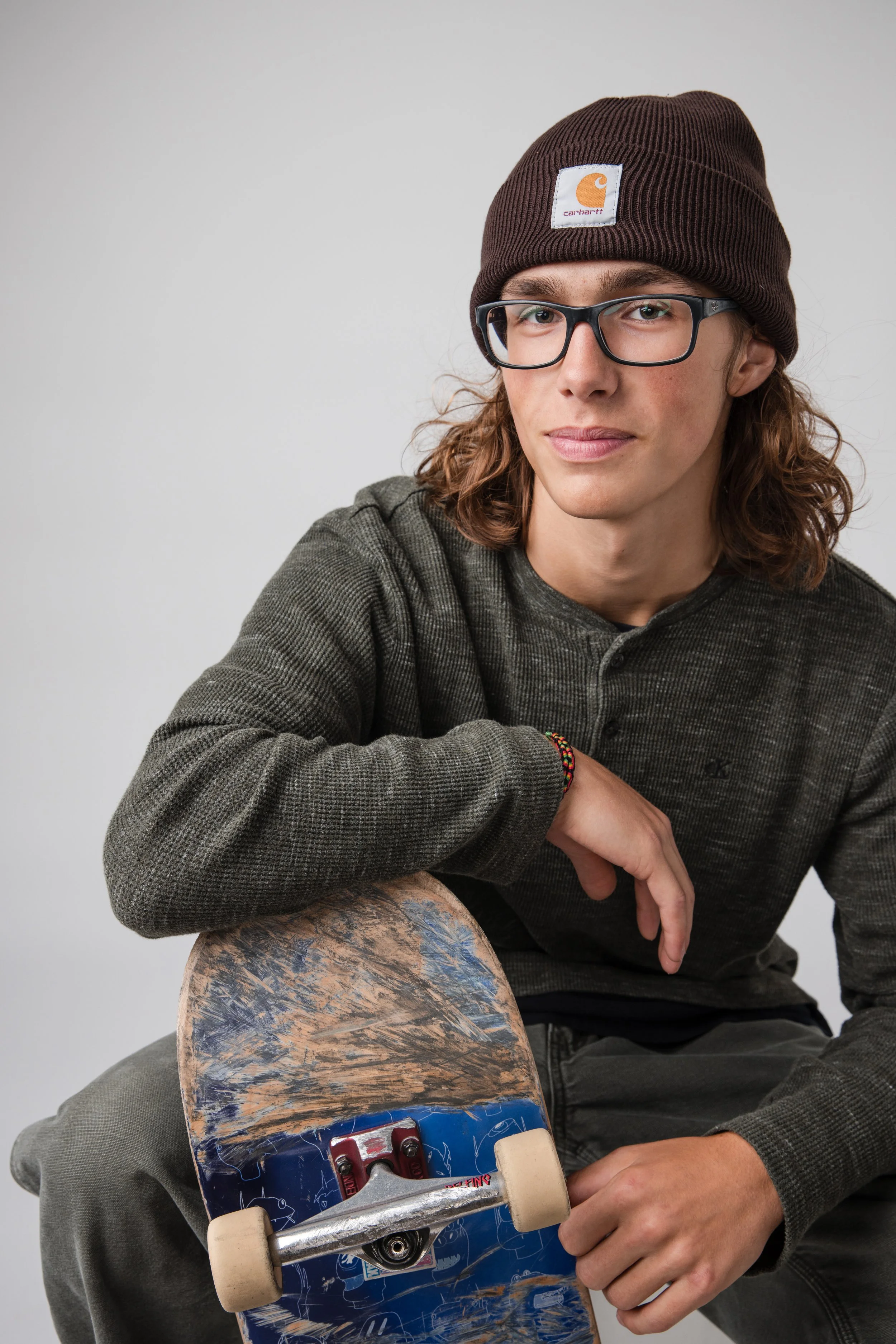 Senior portrait in studio with skateboard at Tiffany Brooks studio.