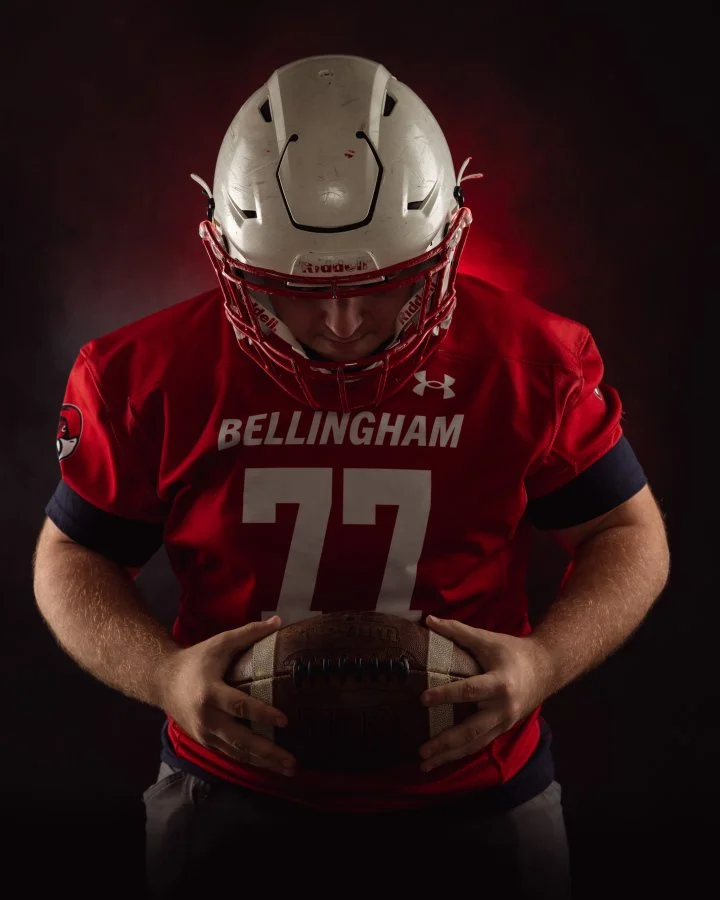 Senior portrait in Tiffany Brooks studio in football gear with football