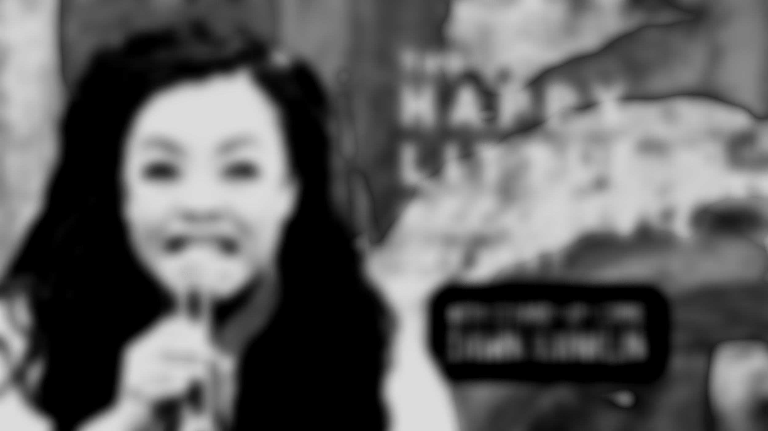 Layout that features woman holding a microphone in the foreground and paint splashes in the background. Title reads: "The Happy Little Accident Podcast, with Stand-up Comic Dawn Xanklin"