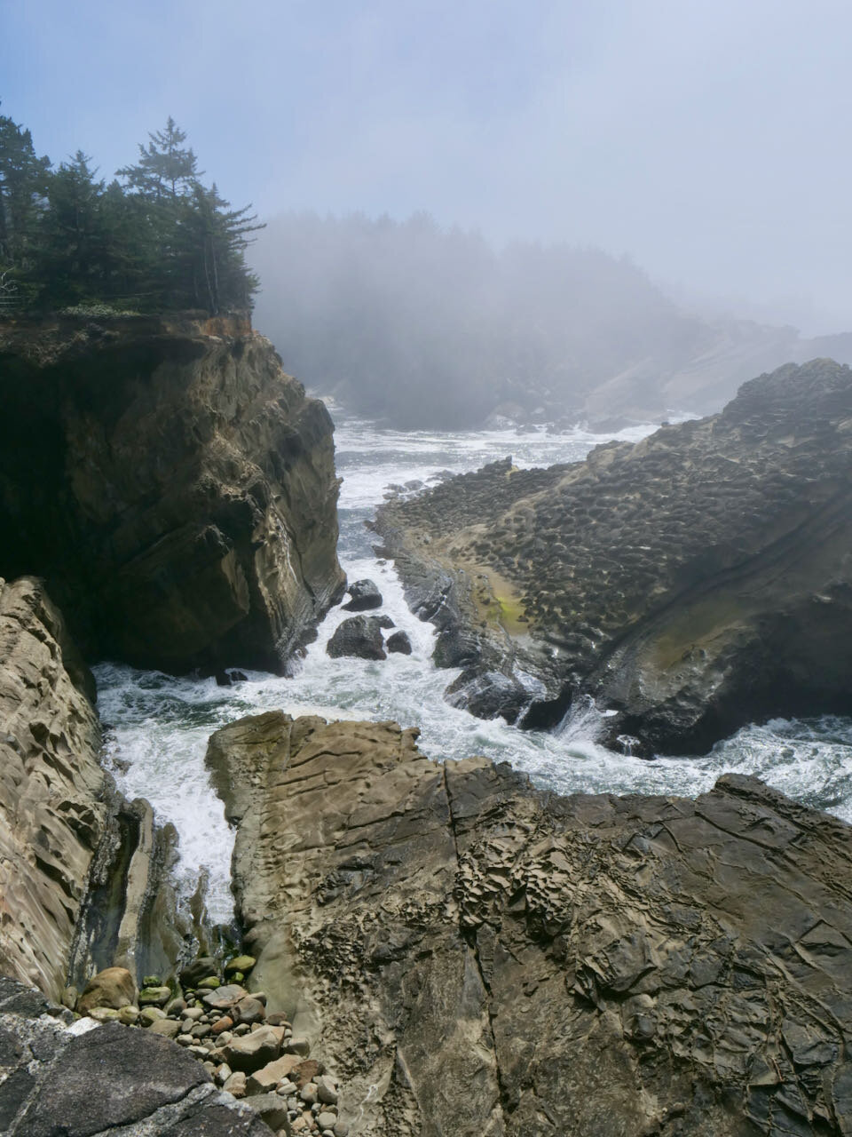 The ocean entering a craggy Oregon Coast inlet