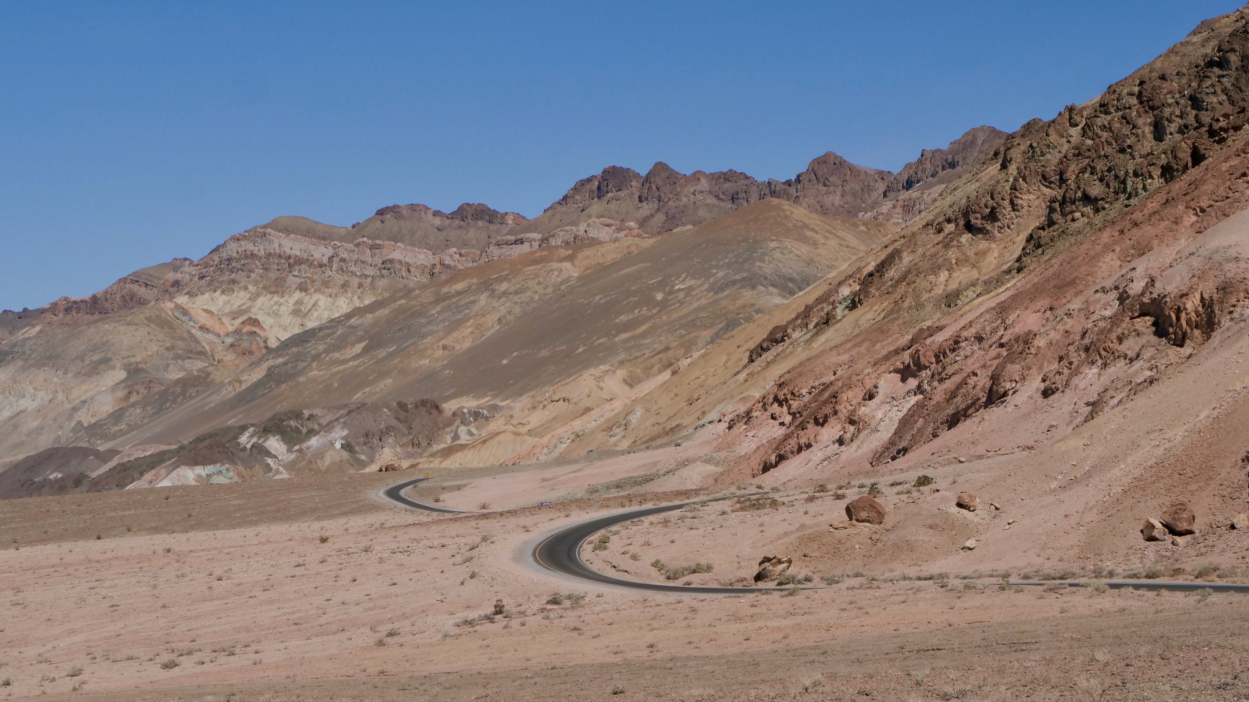 A panoramic desert photograph featuring a road, Desert mountains, 16X9