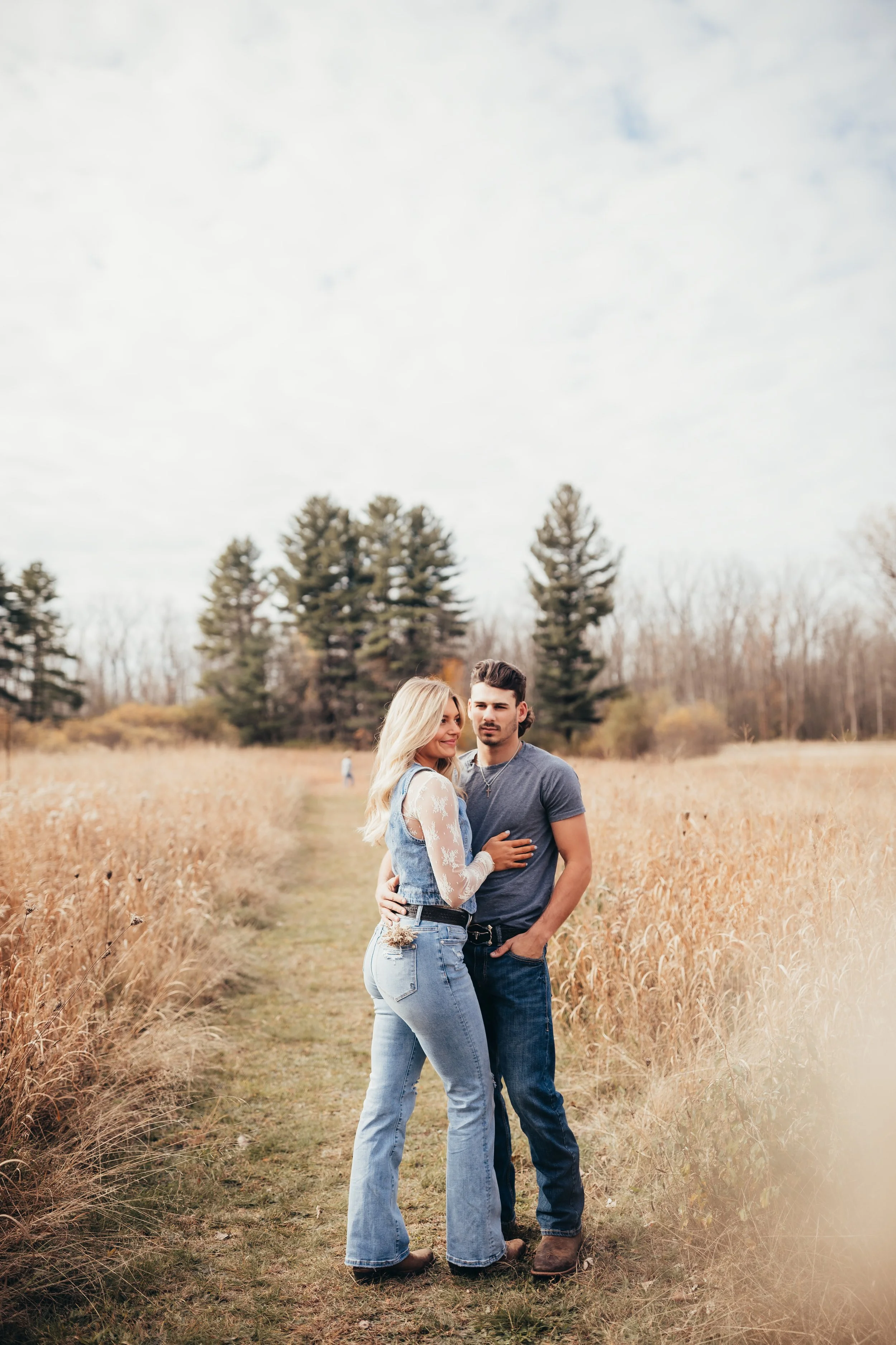 Outdoor lifestyle family photography session parents standing in the field with kids in the background
