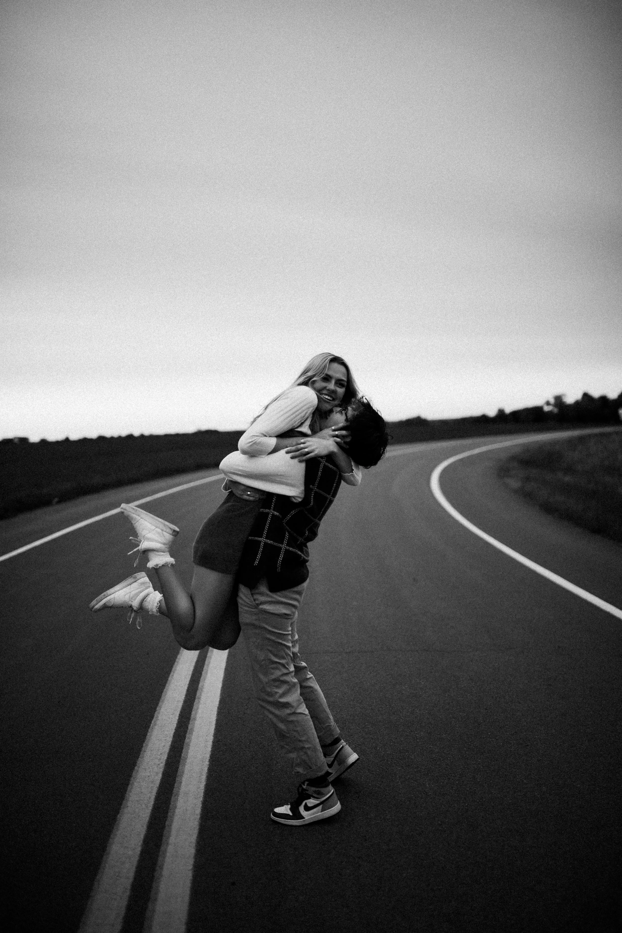 Playful, candid outdoor couples photoshoot in the middle of the road during sunset