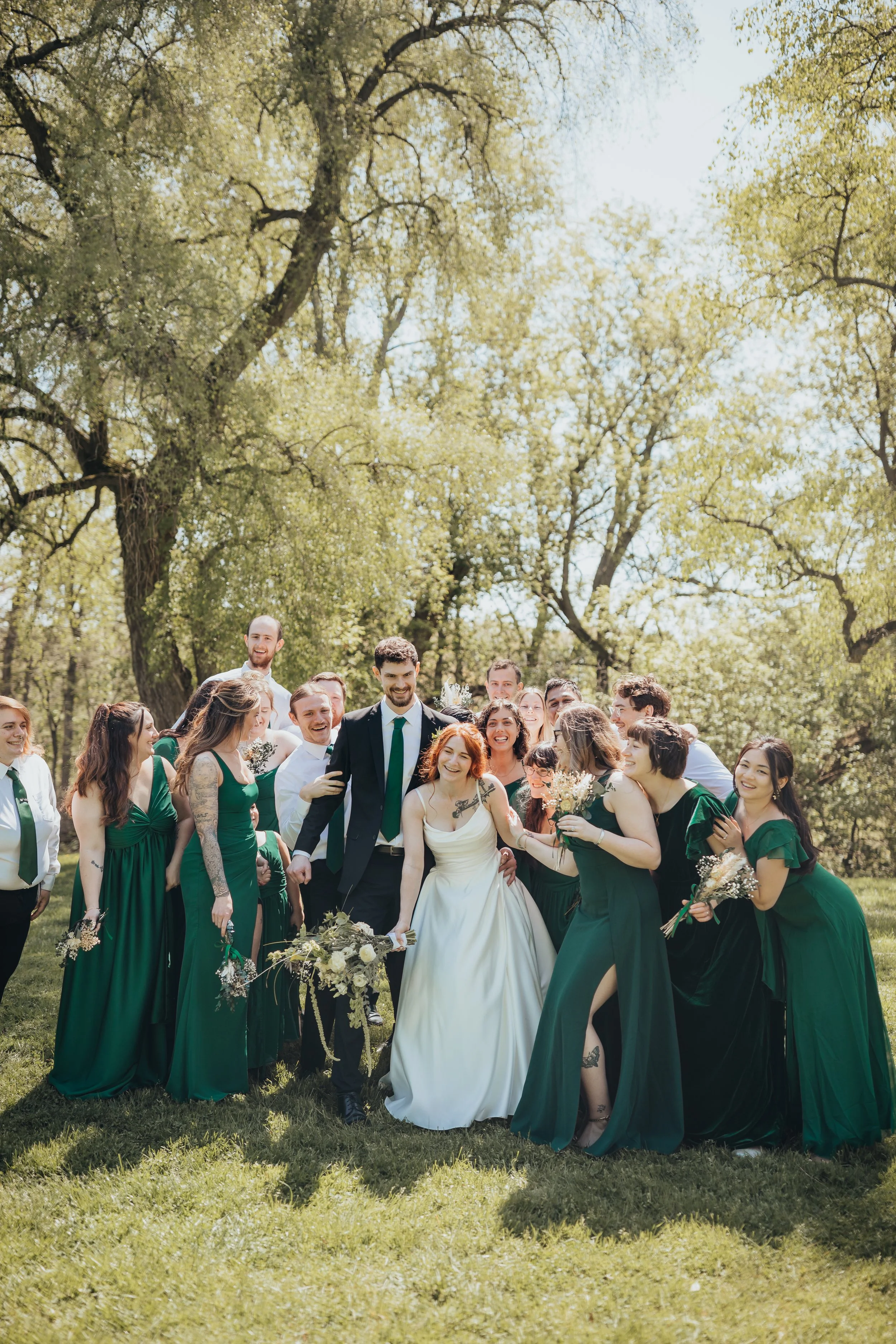 Candid wedding photography of bridal party running up to bride and groom outdoors