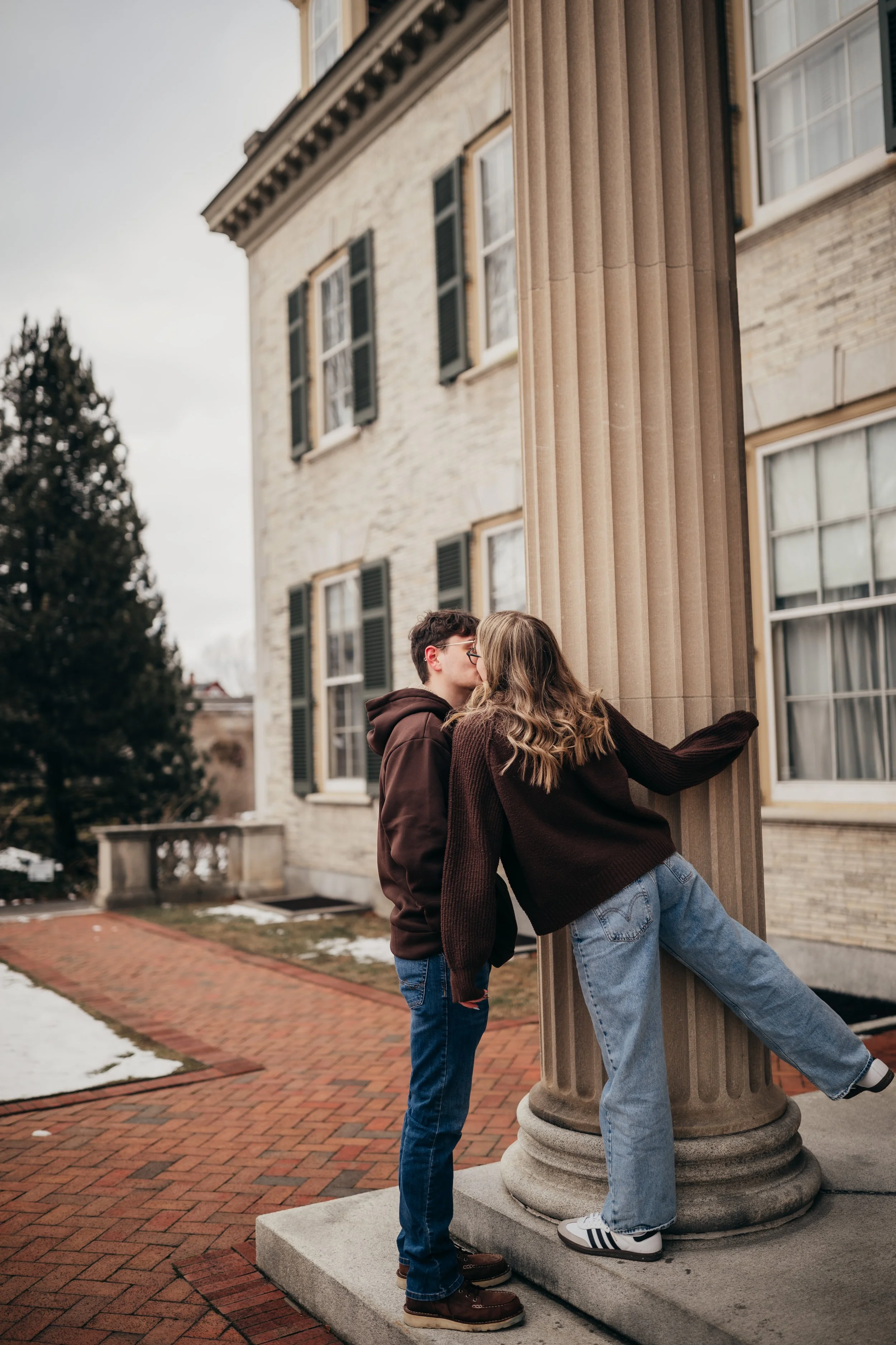 Playful outdoor winter couples photoshoot kissing in downtown Rochester NY