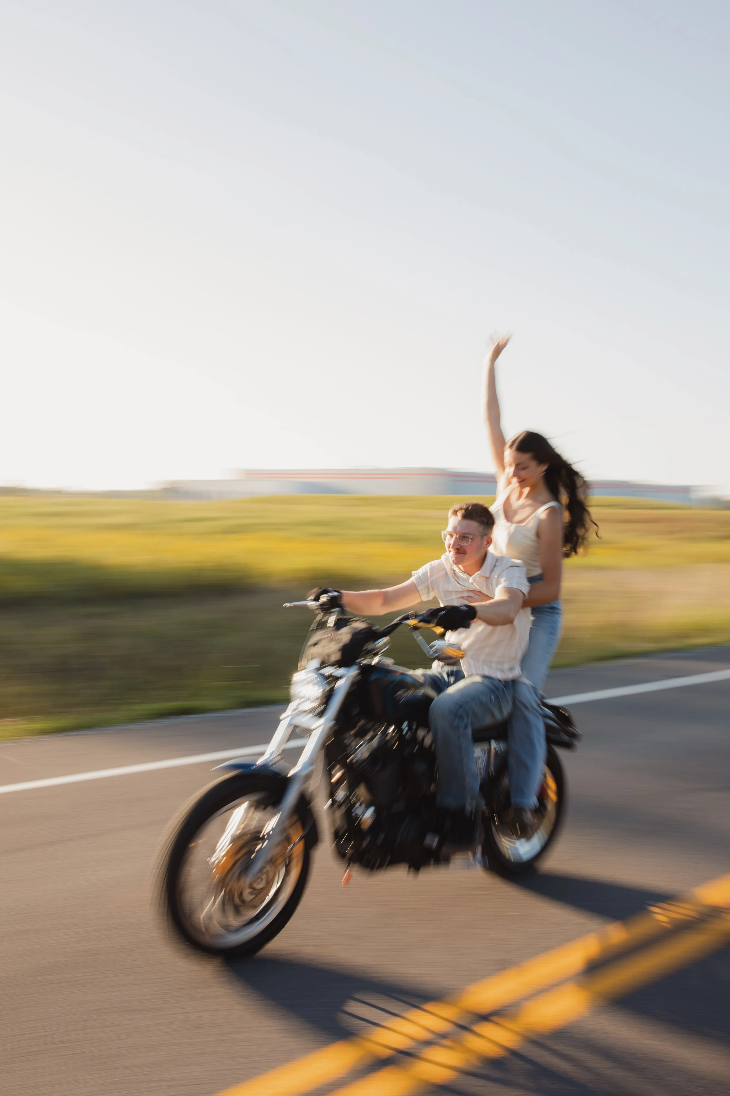 Motion blur action shot of couple riding on motorcycle in Rochester, NY during golden hour